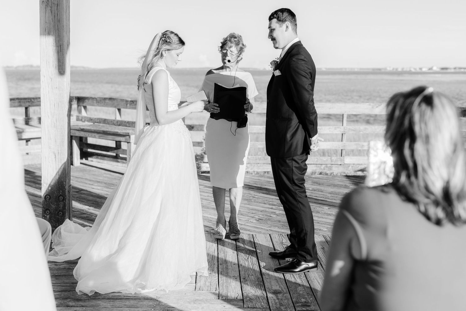 Wedding ceremony candid moments captured in black and white on oceanfront deck southport elopement wedding bride groom light and airy classi