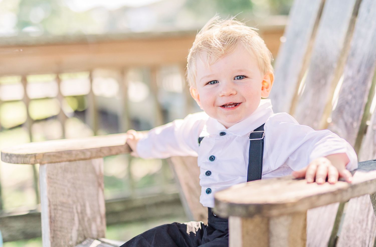 Young child in formal wear smiles on wooden deck southport elopement wedding bride groom light and airy classic