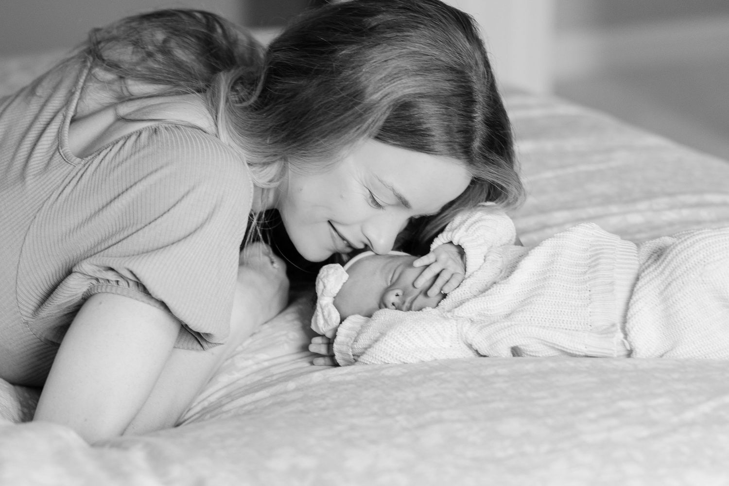 Intimate black and white photos of parent and baby resting together.