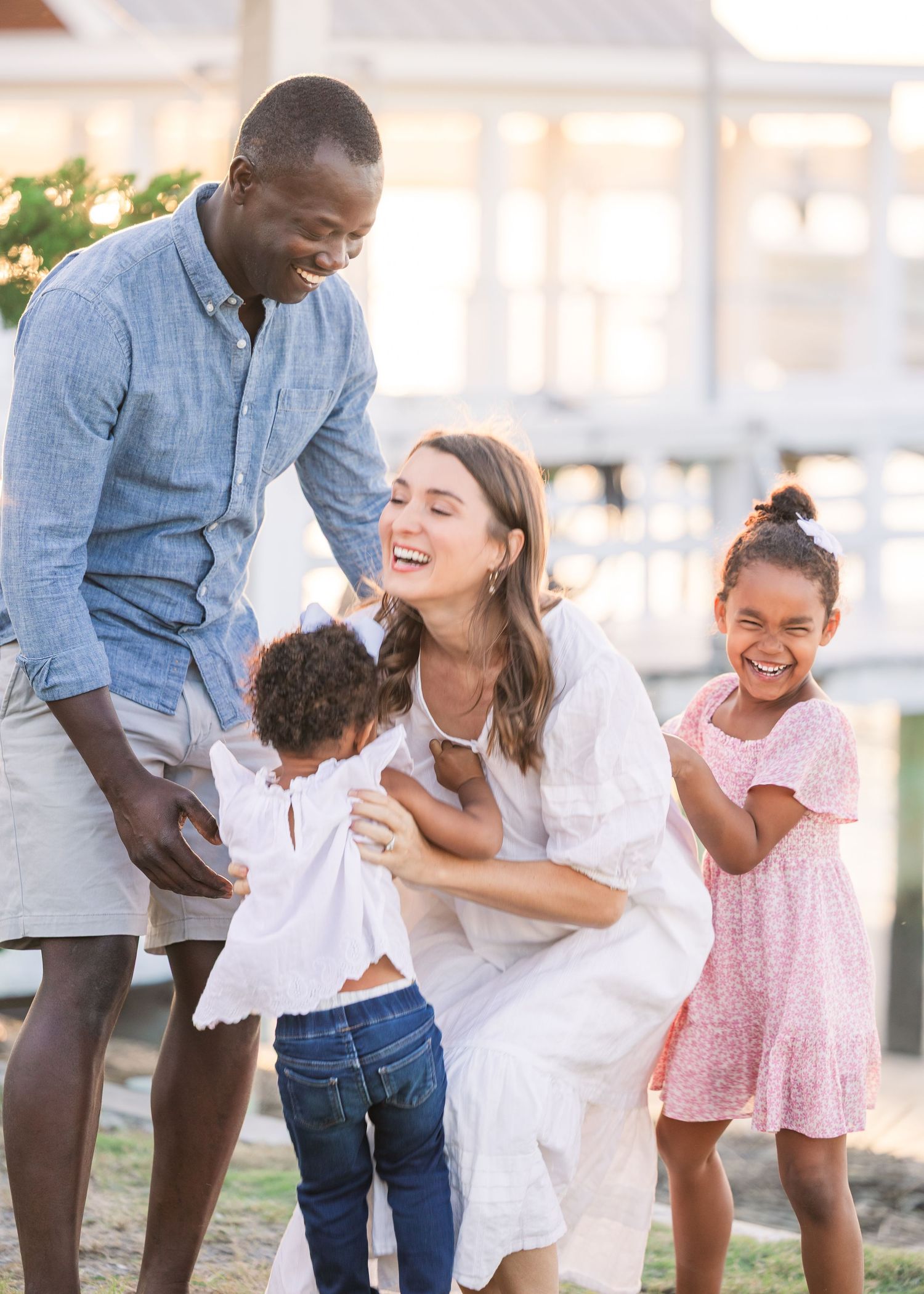 Playful family moment captured during outdoor photo session with natural lighting.