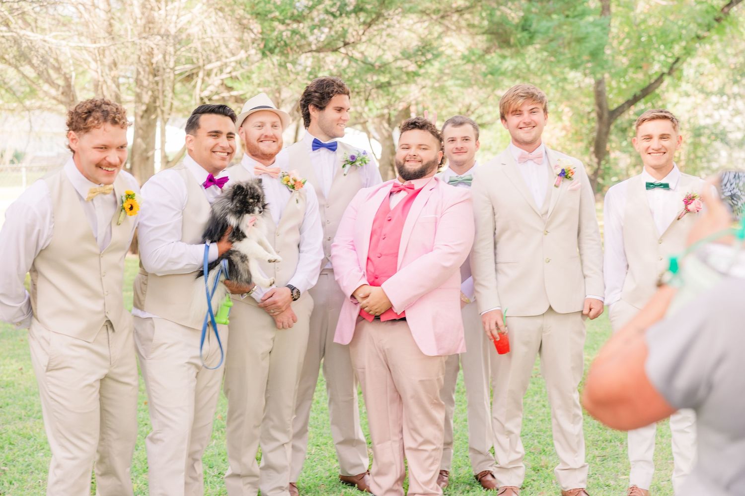 Groomsmen in khaki suits gather outdoors for a fun wedding party photo groom bride wilmington photographer light and airy classic Wrightsvil