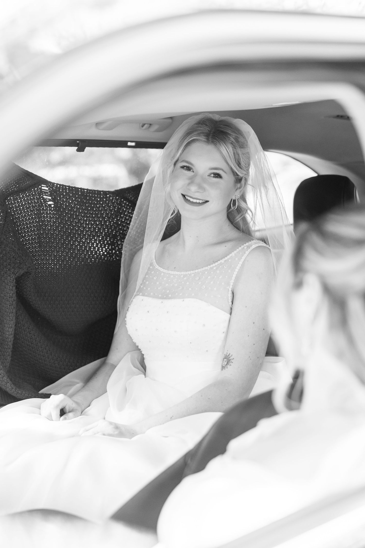 Bride sitting in white car interior wearing traditional wedding dress wedding groom bride wilmington photographer light and airy classic