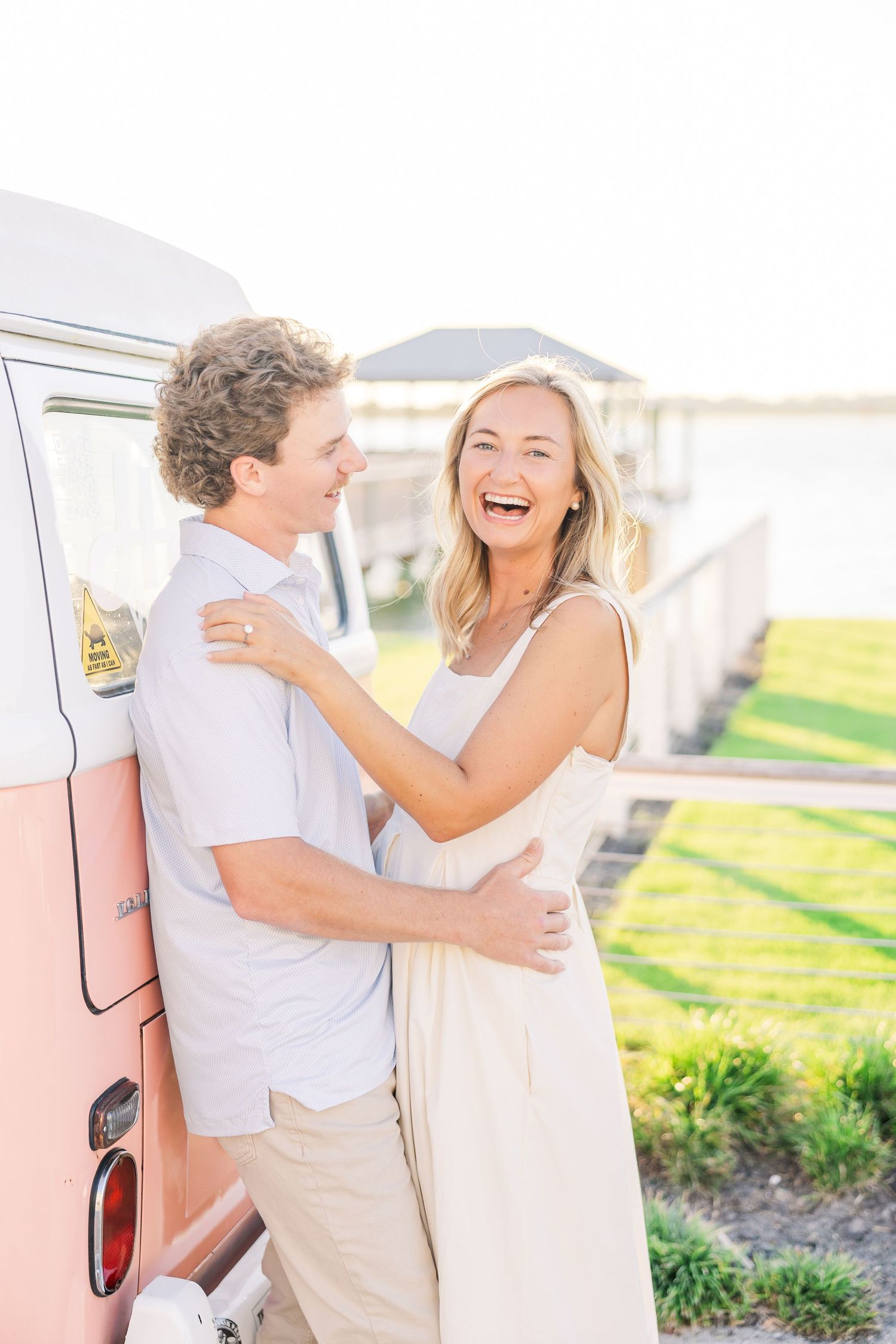 A candid moment of laughter and joy shared between a couple next to a vintage van.