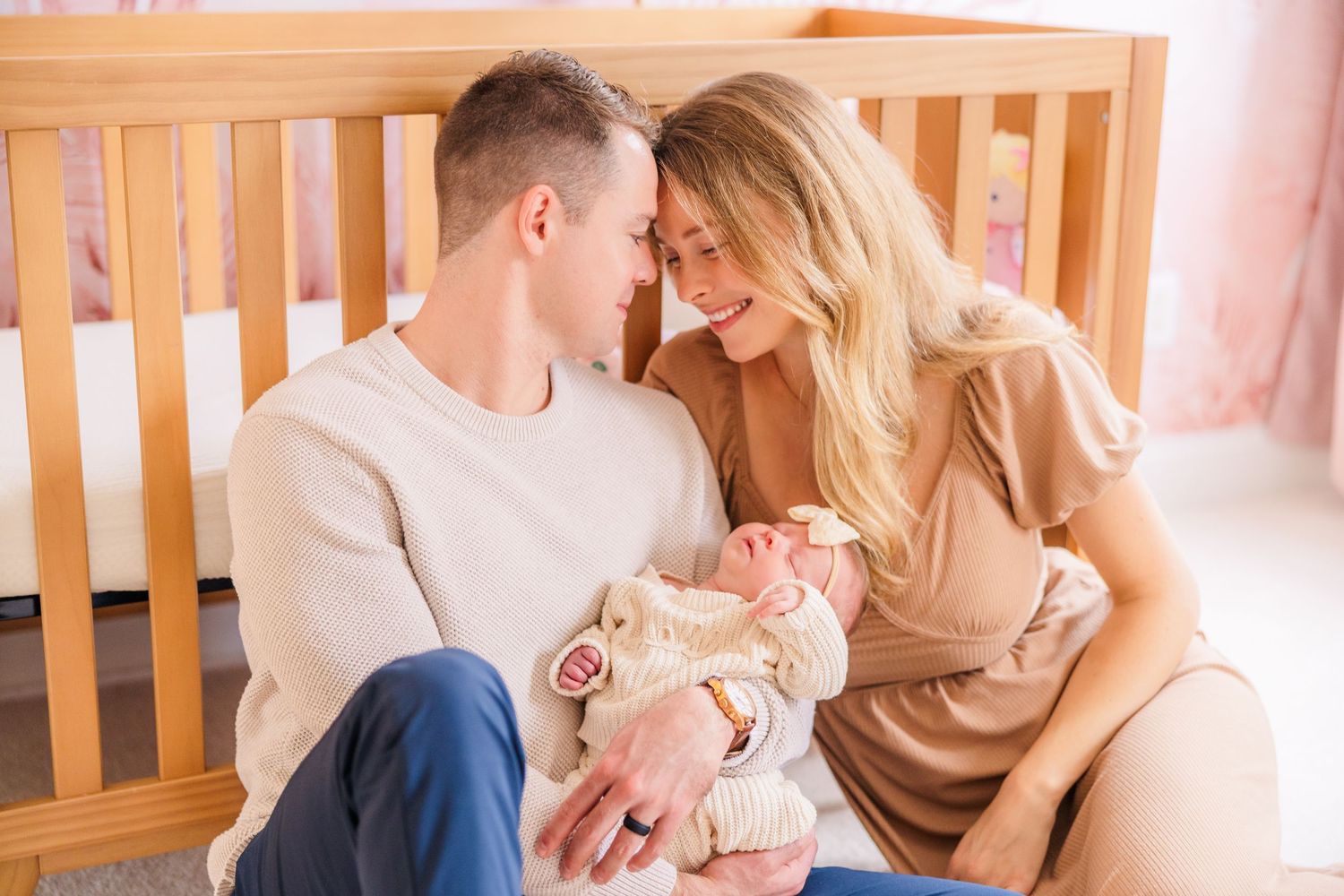 Family portrait session in a warm-toned nursery with natural lighting.