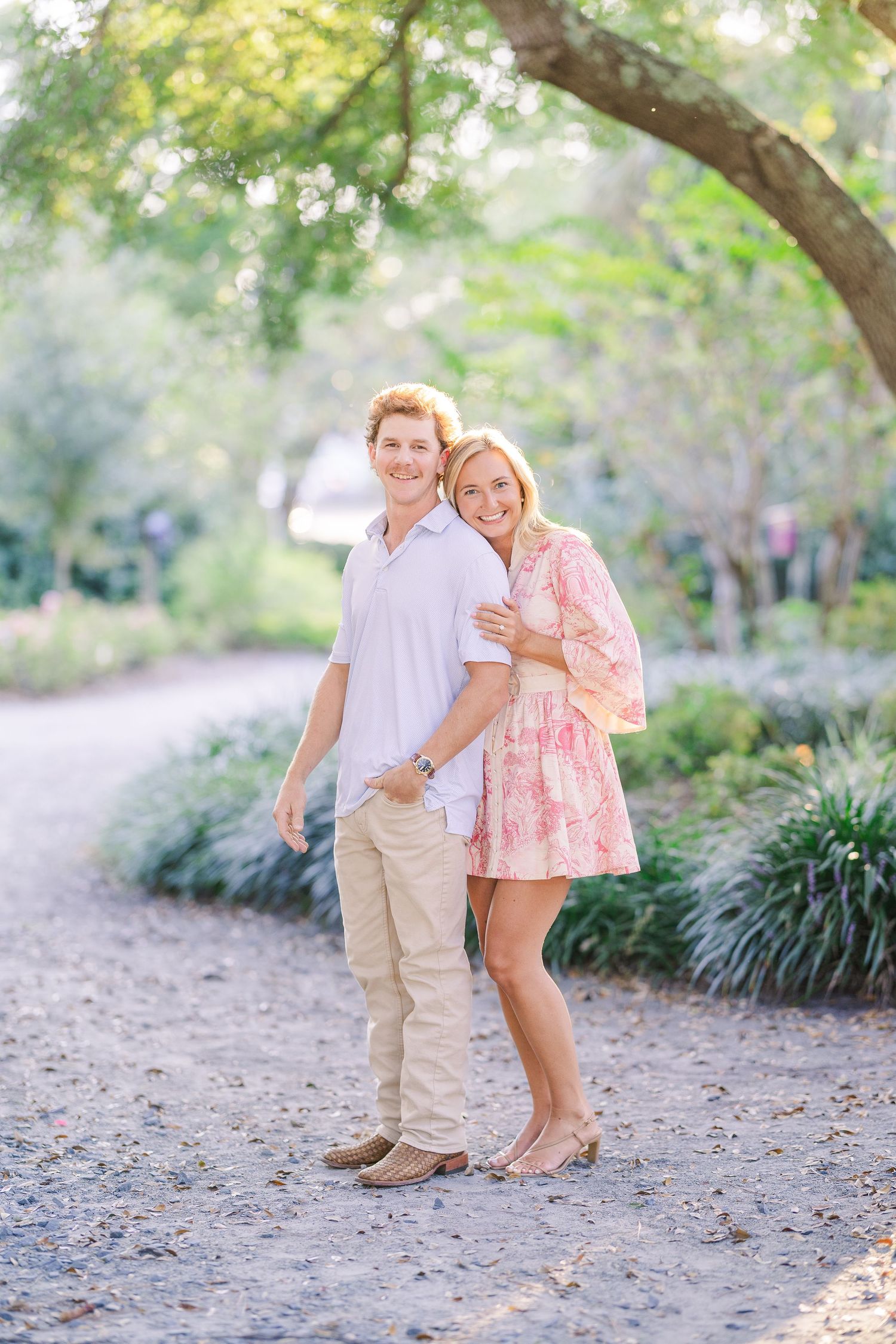 Couple sharing joyful moments on a garden path surrounded by greenery.