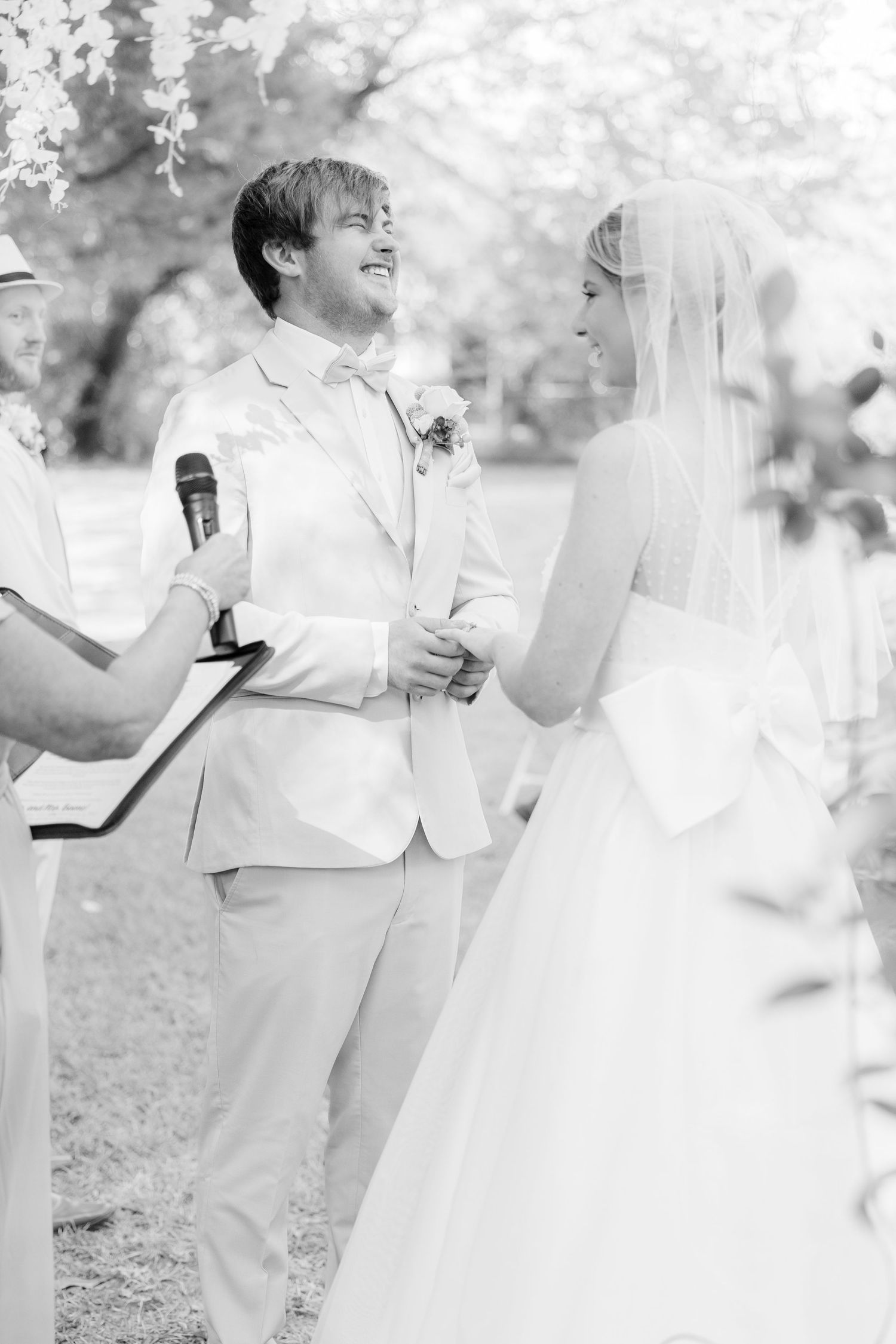 Black and white photo showing joyful moments during an outdoor wedding ceremony bride groom candid light and airy wilmington