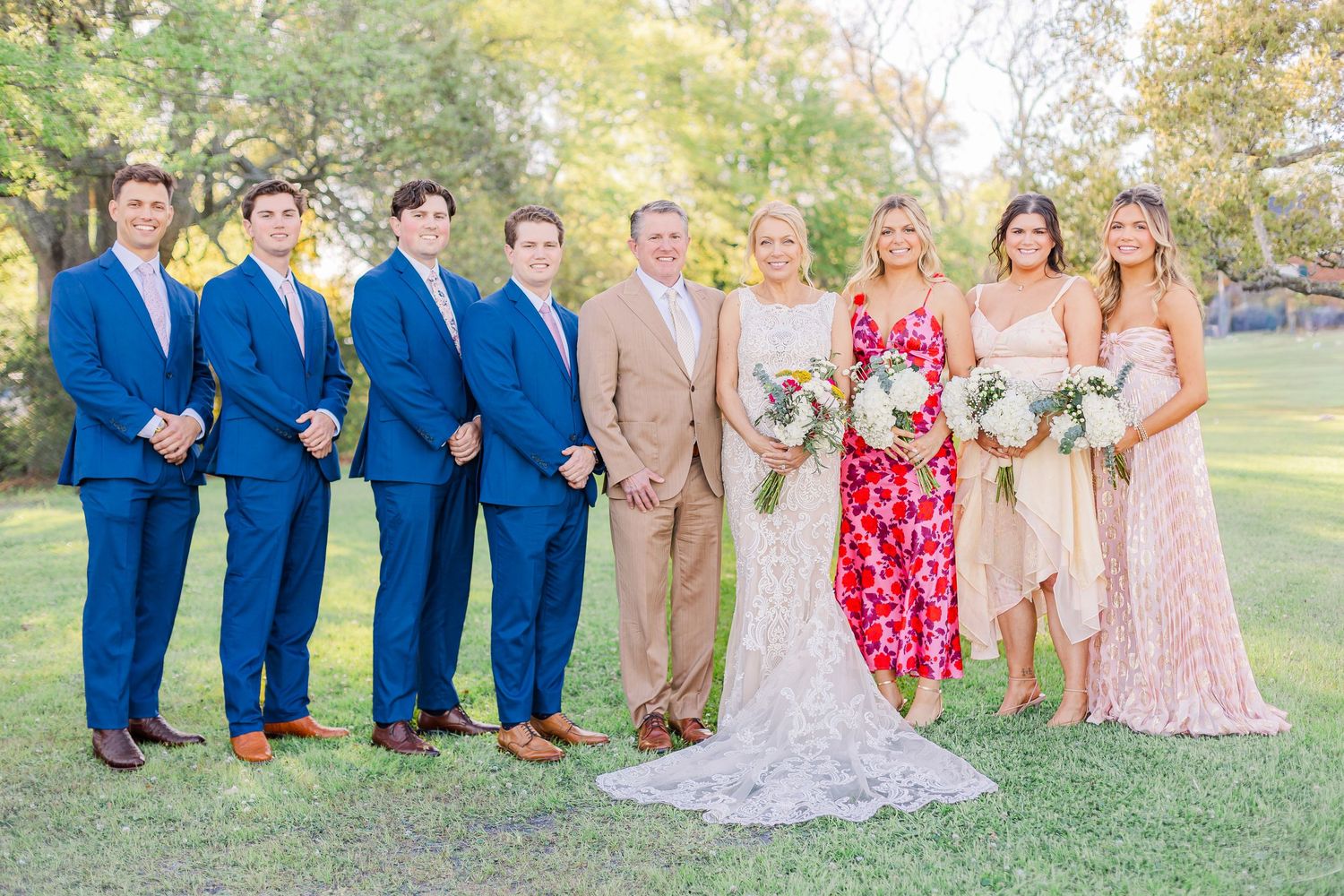 Wedding party outdoors wearing blue suits and pink dresses wedding groom bride wilmington North Carolina photographer light airy