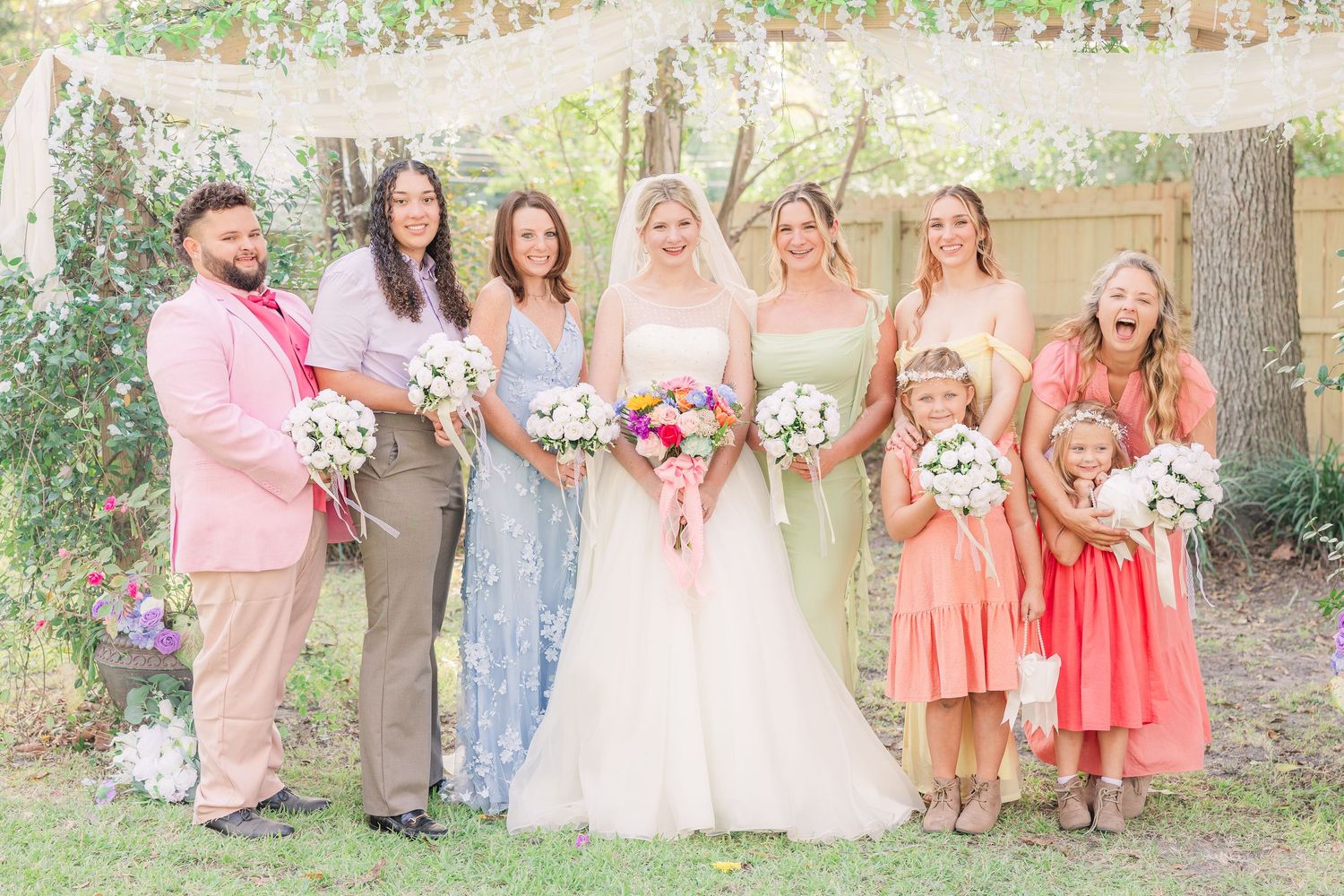 Wedding party poses together outdoors with coral and khaki color scheme wedding groom bride wilmington photographer light and airy classic