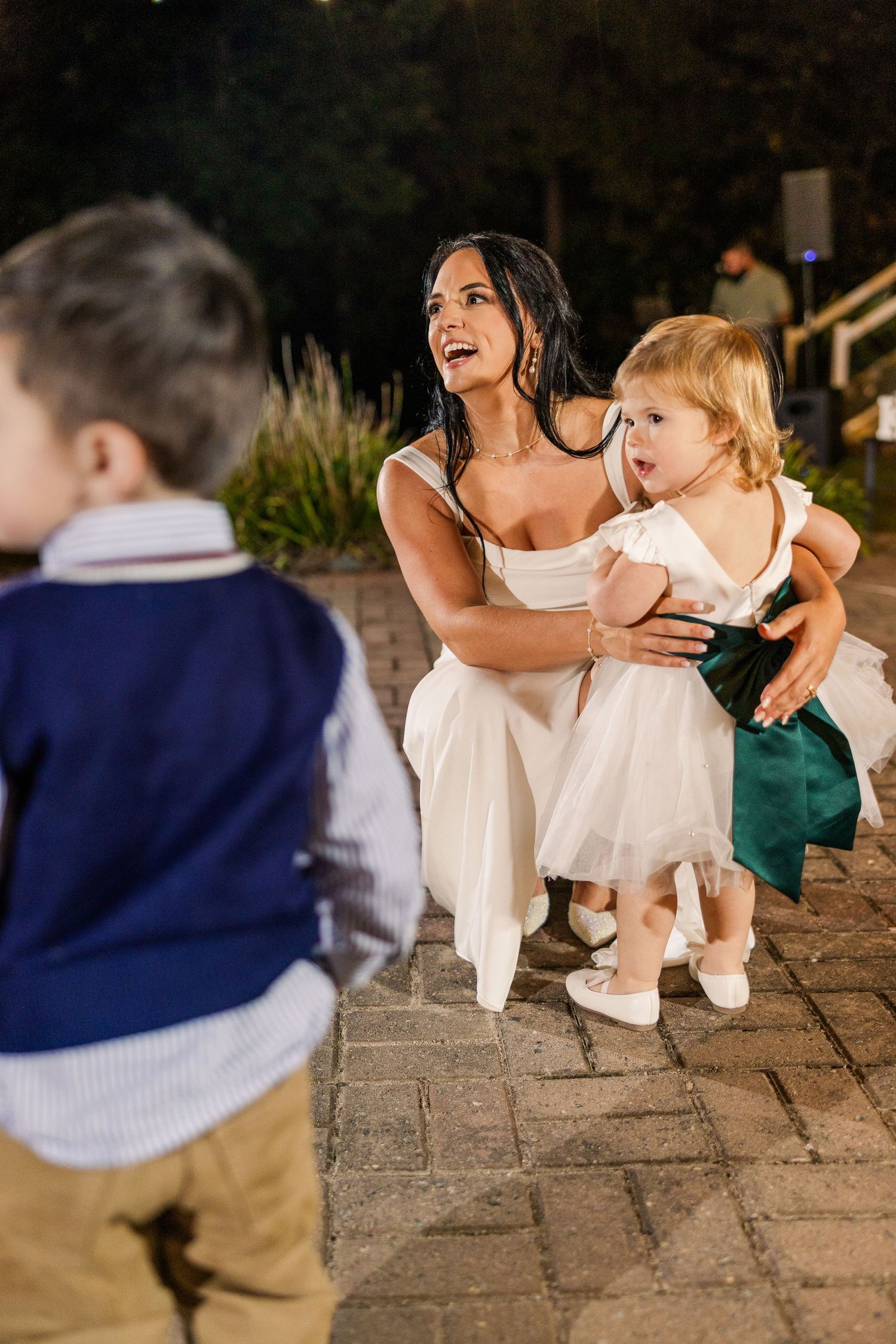 Wedding guests and children dancing together on outdoor stone patio wedding groom bride lake Gaston photographer light airy