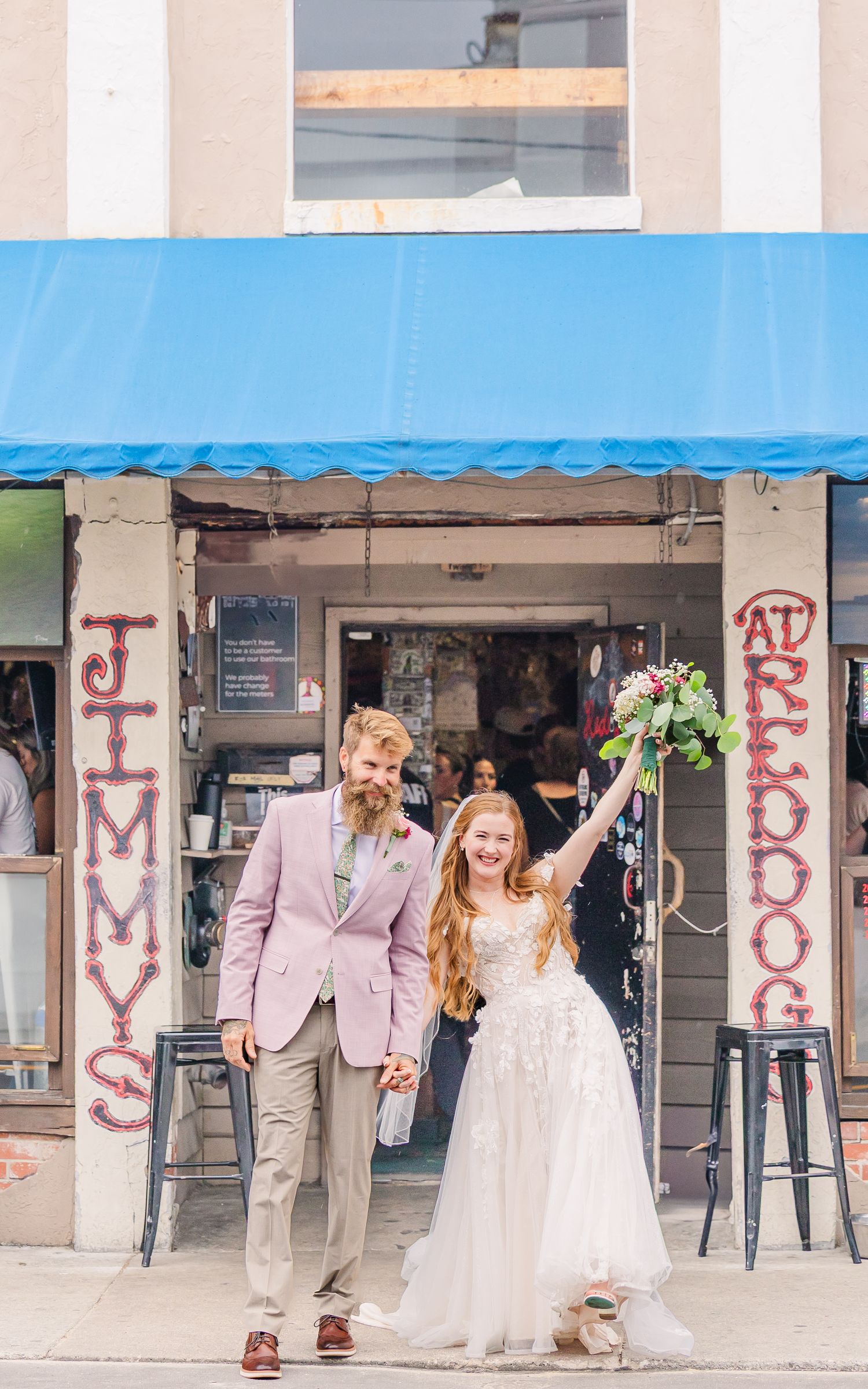 Newlyweds celebrate outside Jimmy's storefront with bride holding bouquet in Wrightsville Beach, nc near wilmington