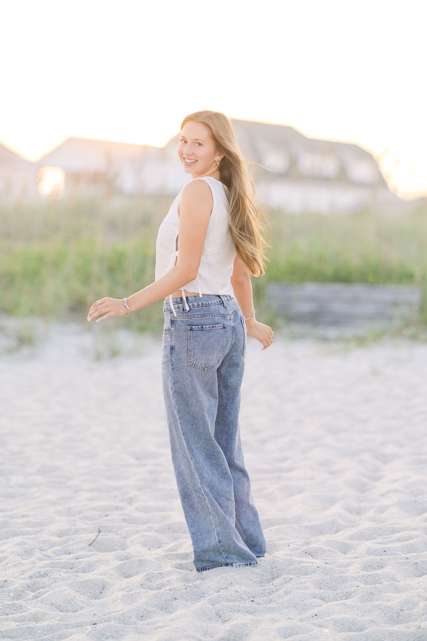 Candid beach photos showing movement and joy in casual denim style.