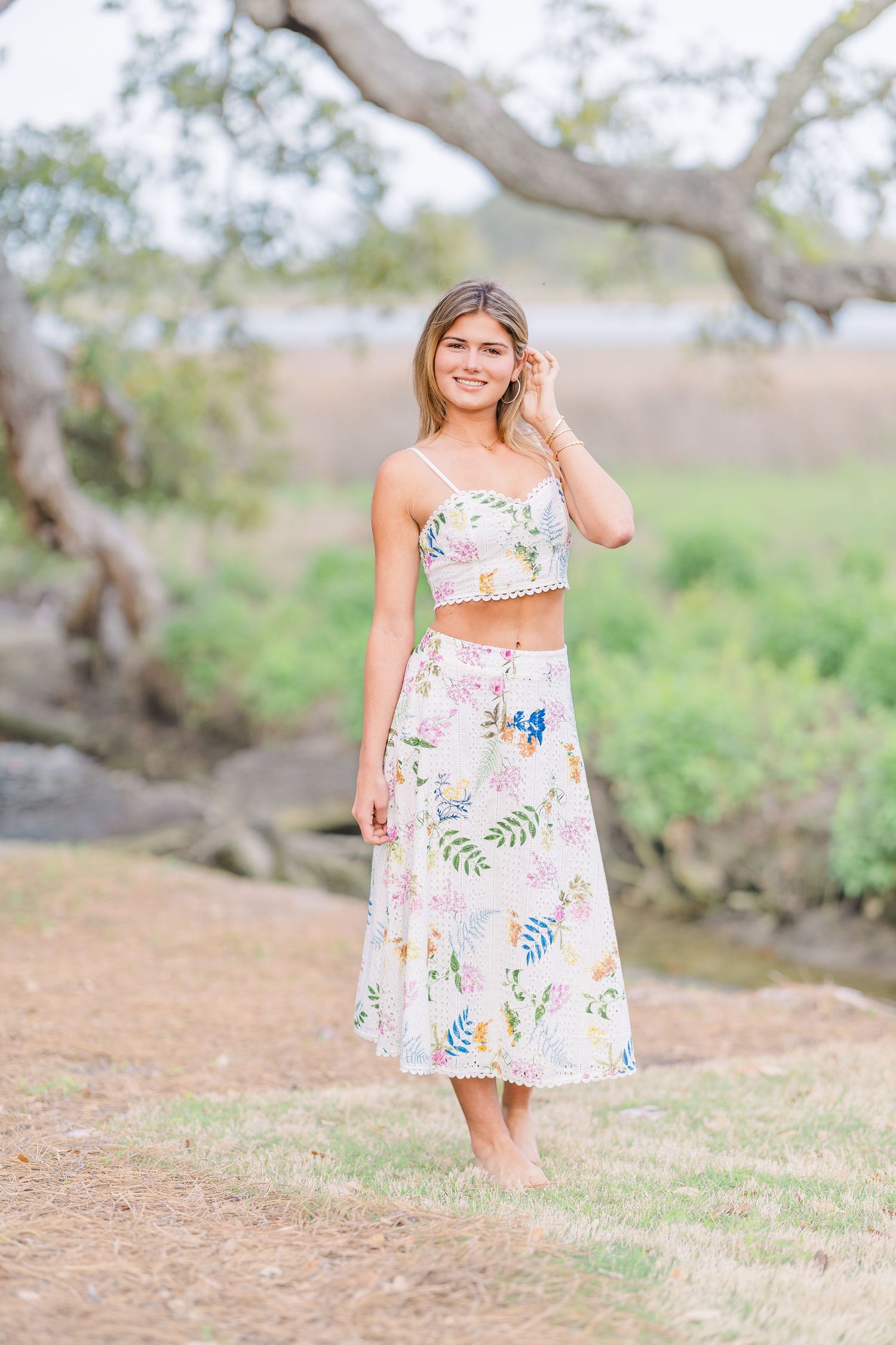 Floral sundress captured in a natural outdoor setting with trees and dirt path.