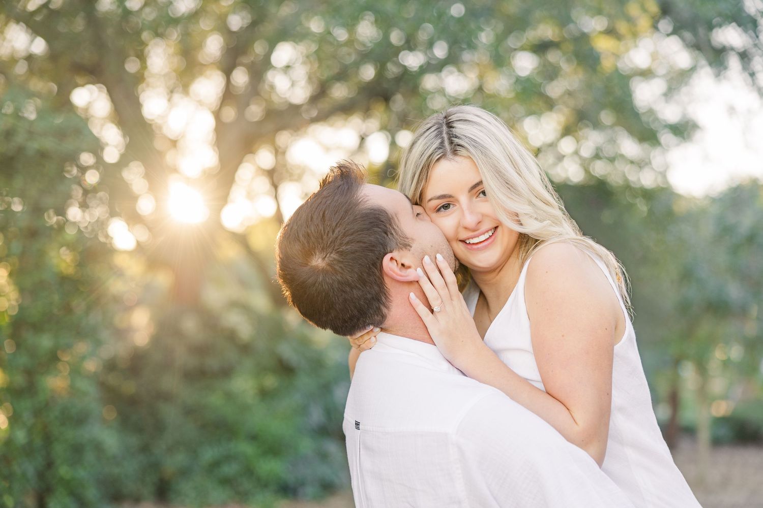 A romantic couple shares tender moments in an outdoor setting with soft natural lighting.