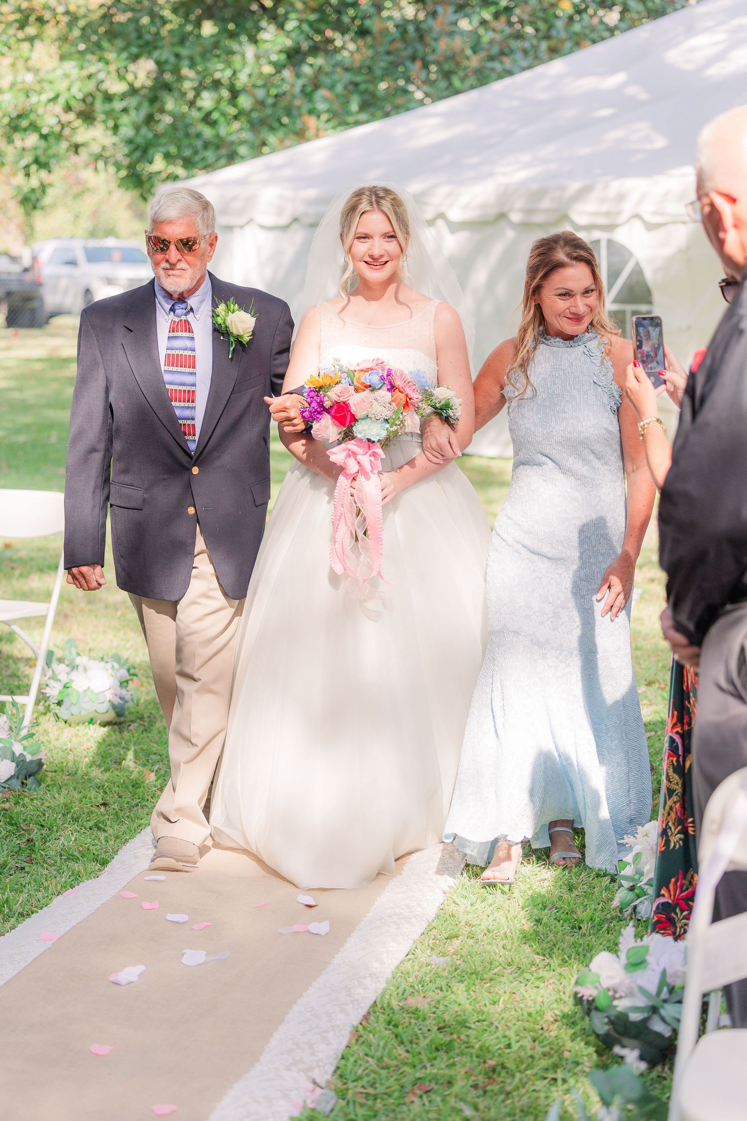 Wedding party walks down an outdoor aisle wedding groom bride wilmington photographer light and airy classic Wrightsville Beach
