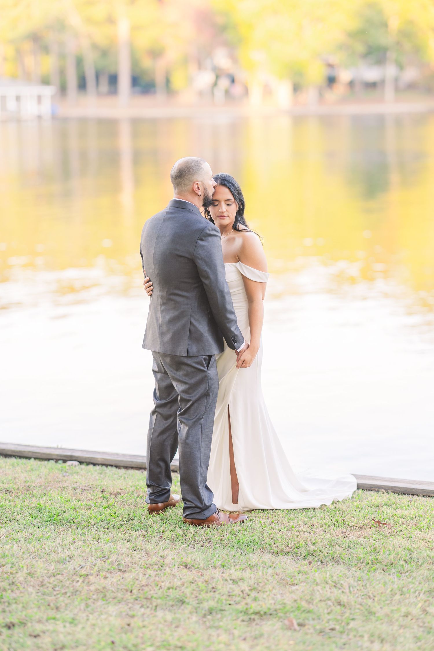 Romantic lakeside wedding photos with warm fall colors reflecting on the water wedding groom bride lake Gaston photographer light airy
