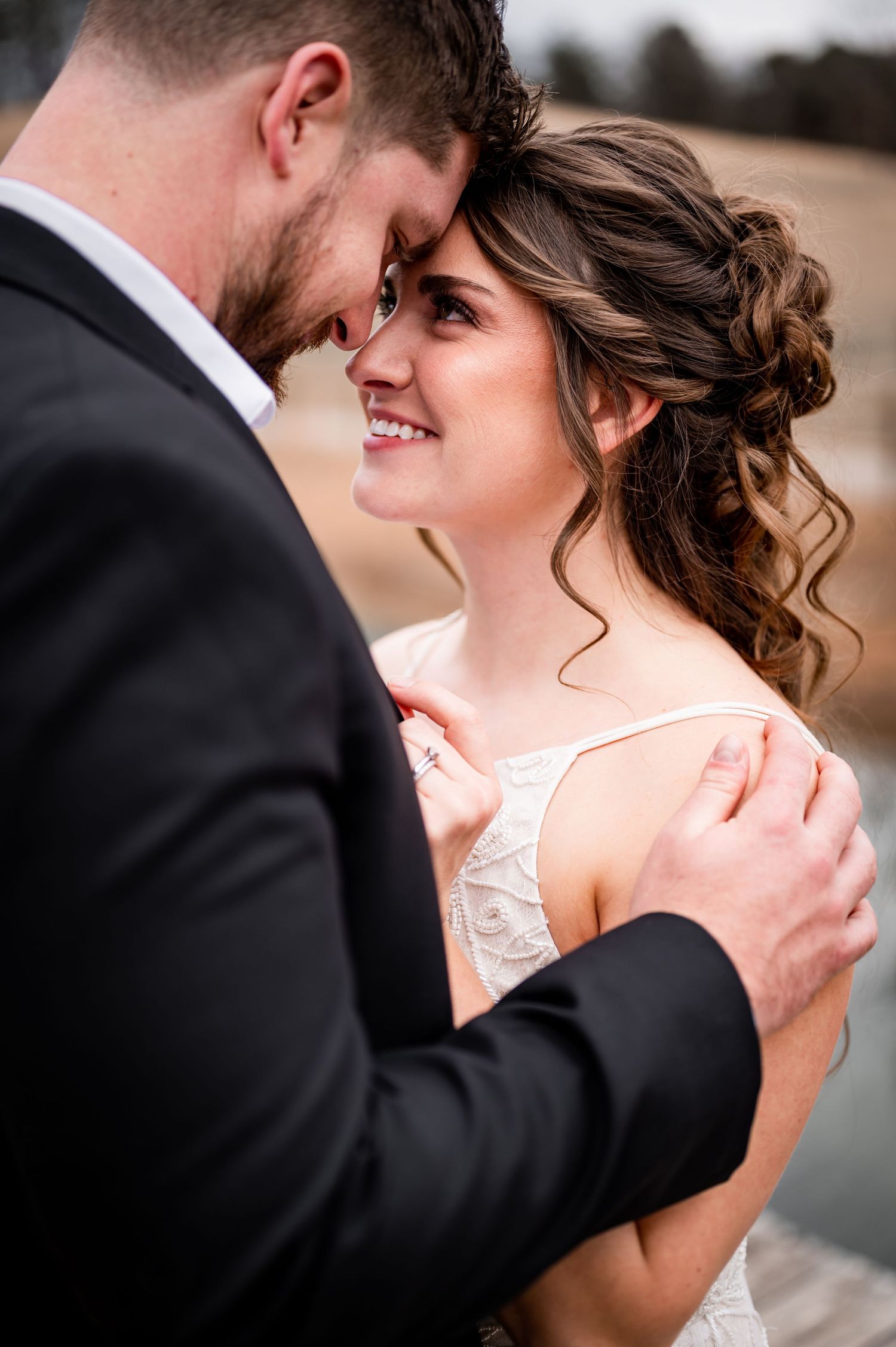 Close-up wedding portrait of the bride and groom standing close together.