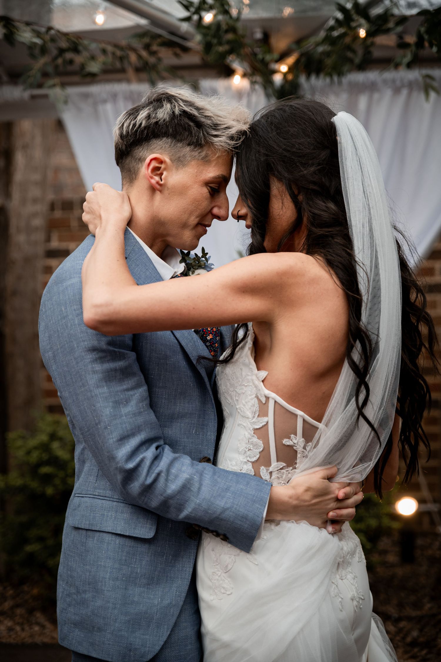 Bride and groom dancing together inside a decorated wedding venue.