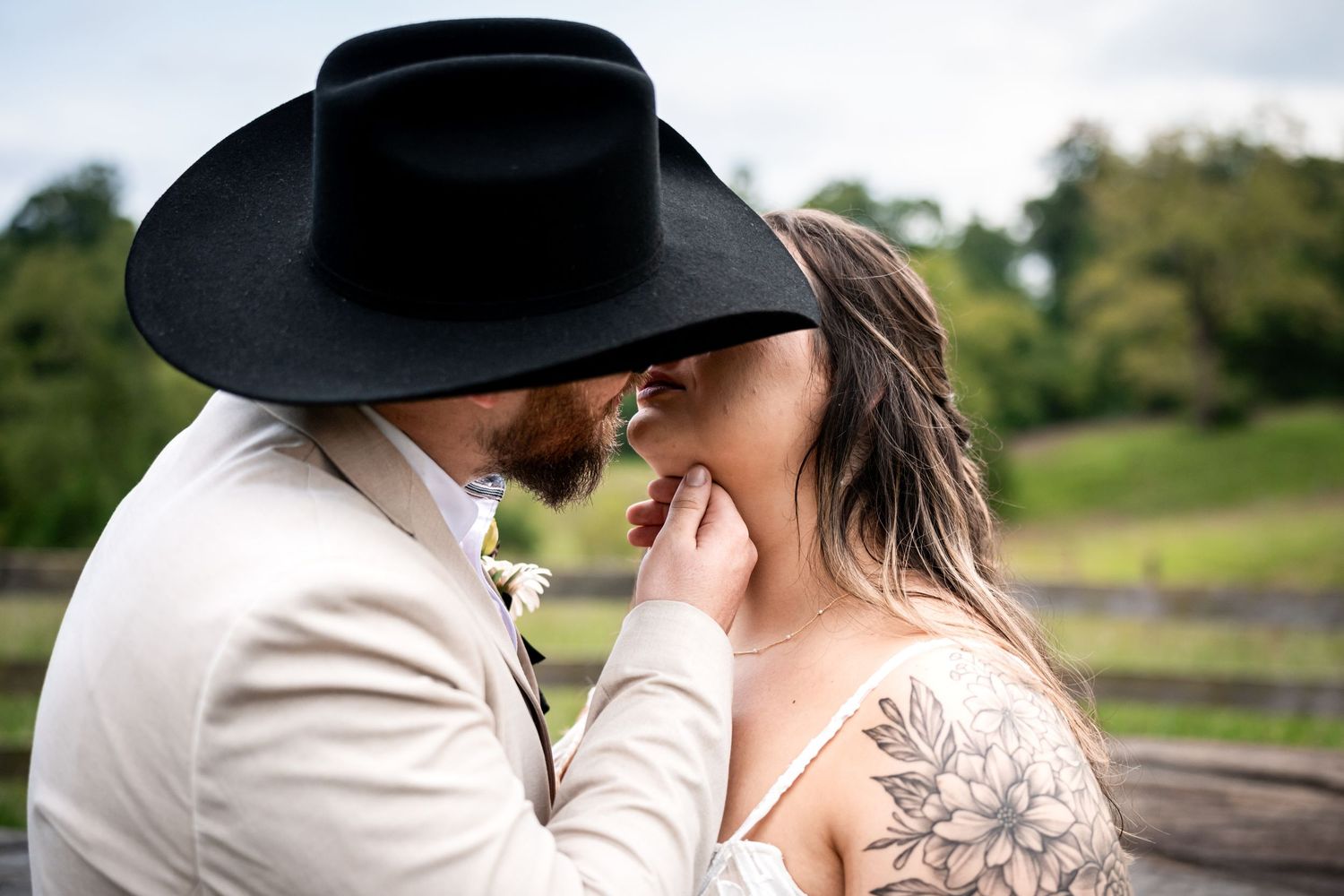 Couple wearing western attire standing together outdoors.