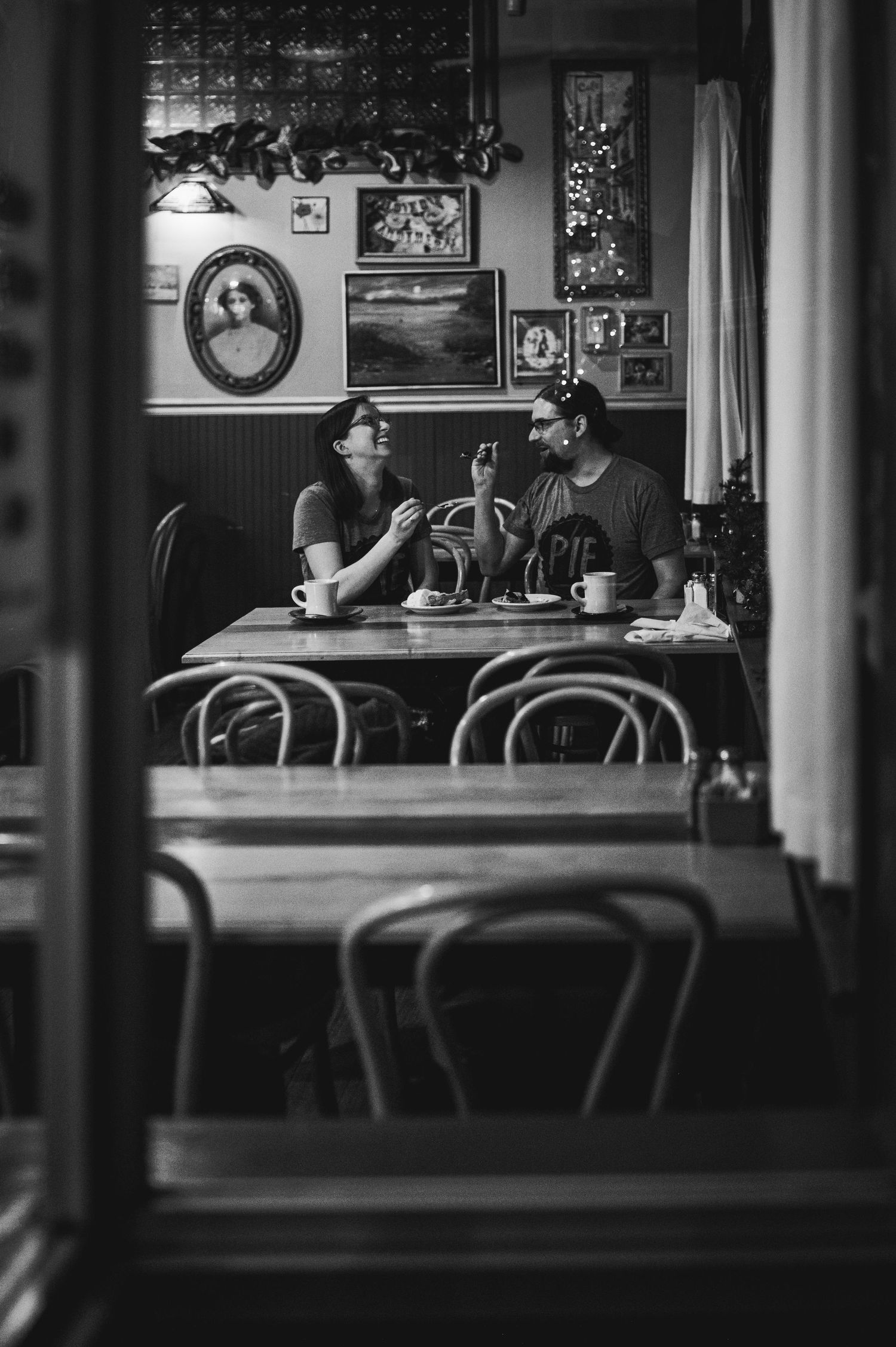 Black and white interior photo of a vintage café featuring classic furniture and wall decor.