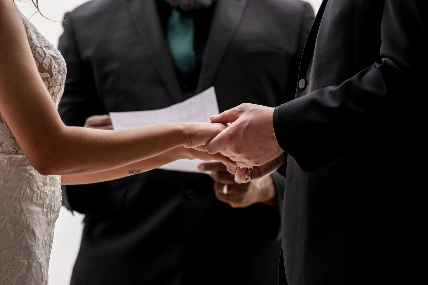 Close-up of hands exchanging wedding rings during the wedding ceremony.