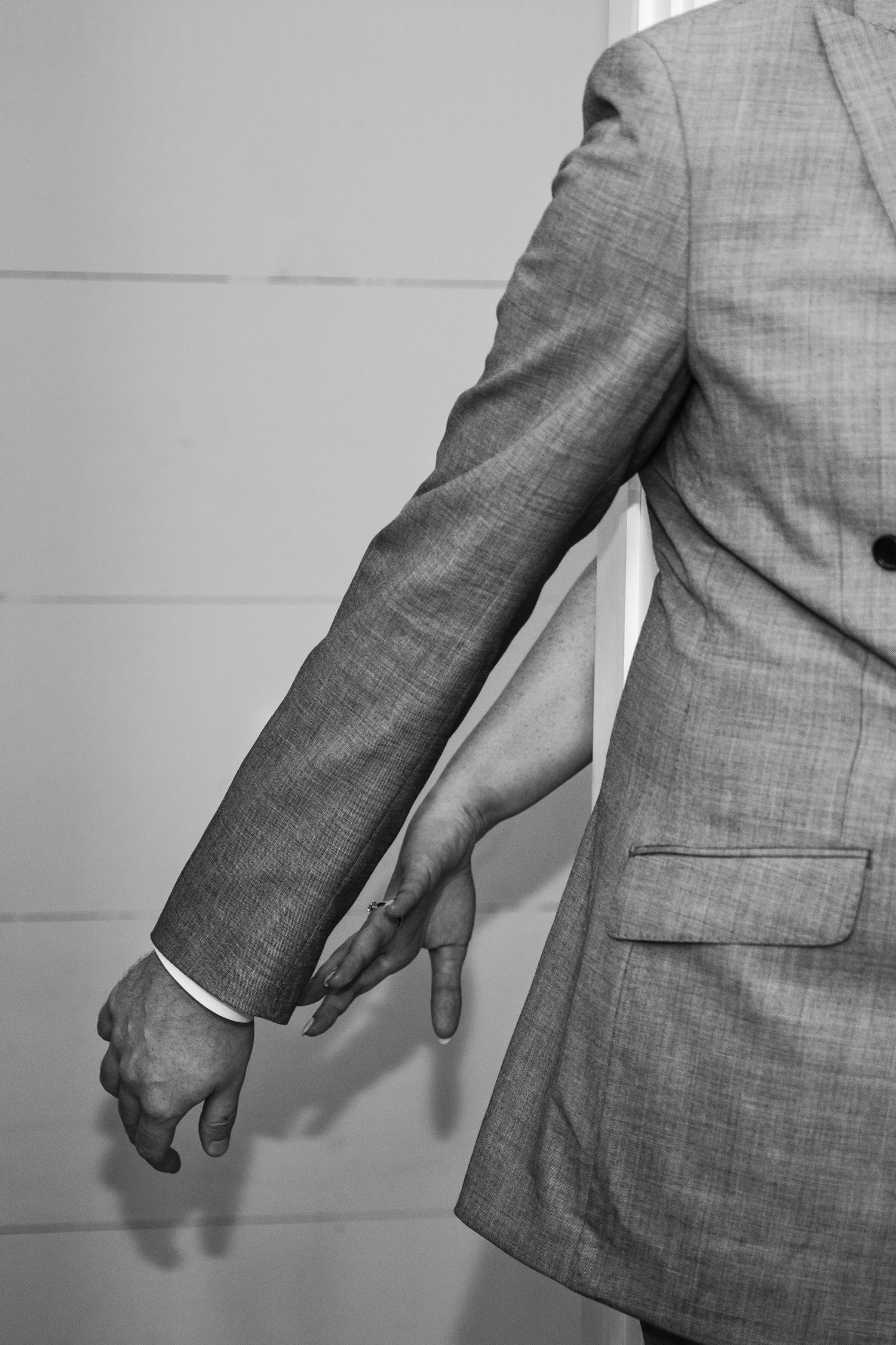 Close-up of two people reaching for each other’s hands in a doorway for first feel.