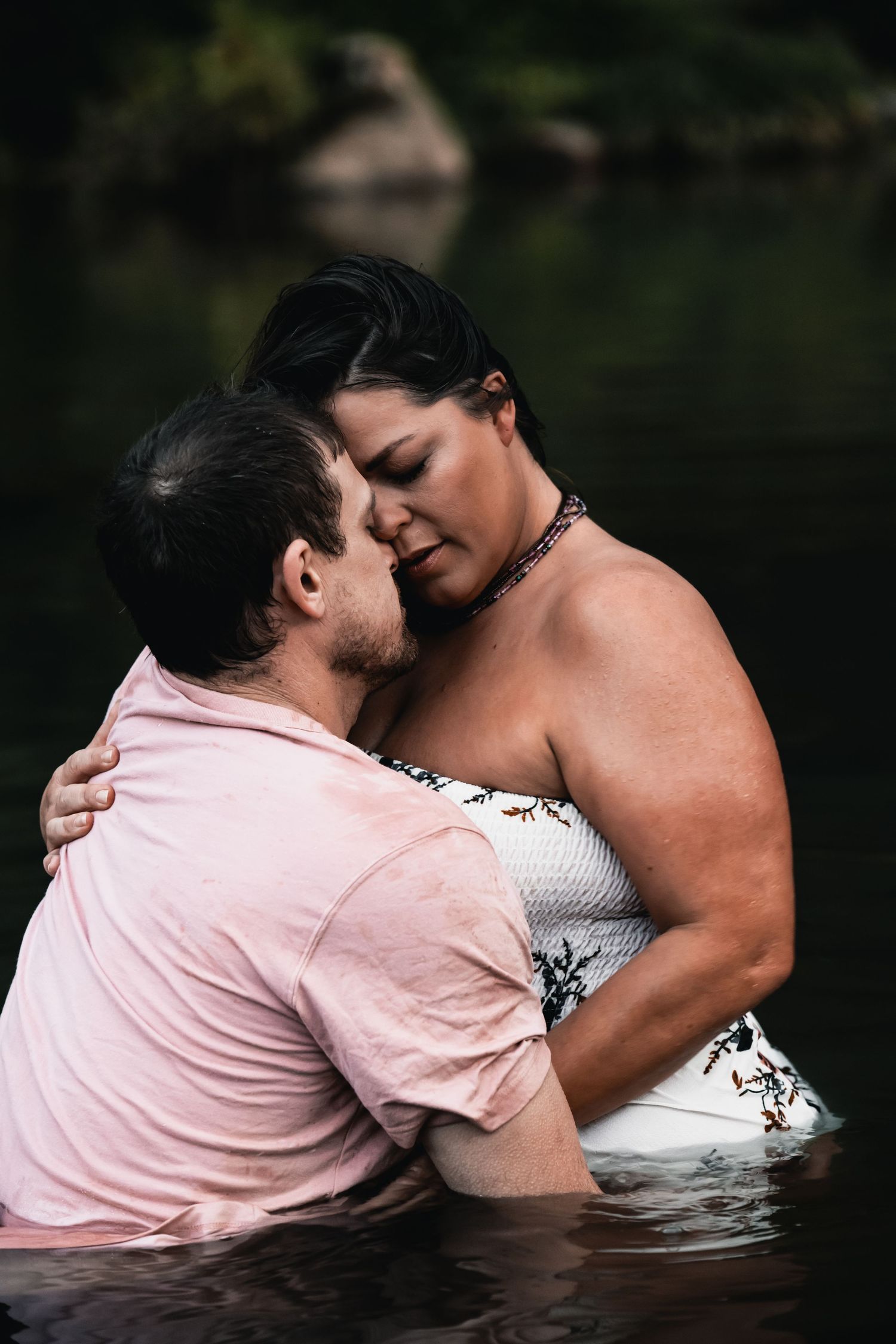 Couple standing together in shallow water of Roanoke River during a sunset portrait session.