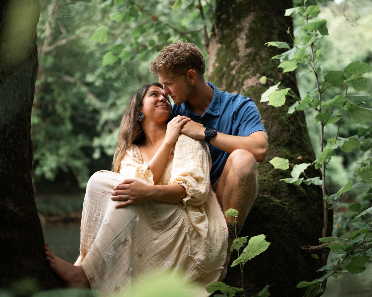 Couple embracing in a garden setting with natural light.