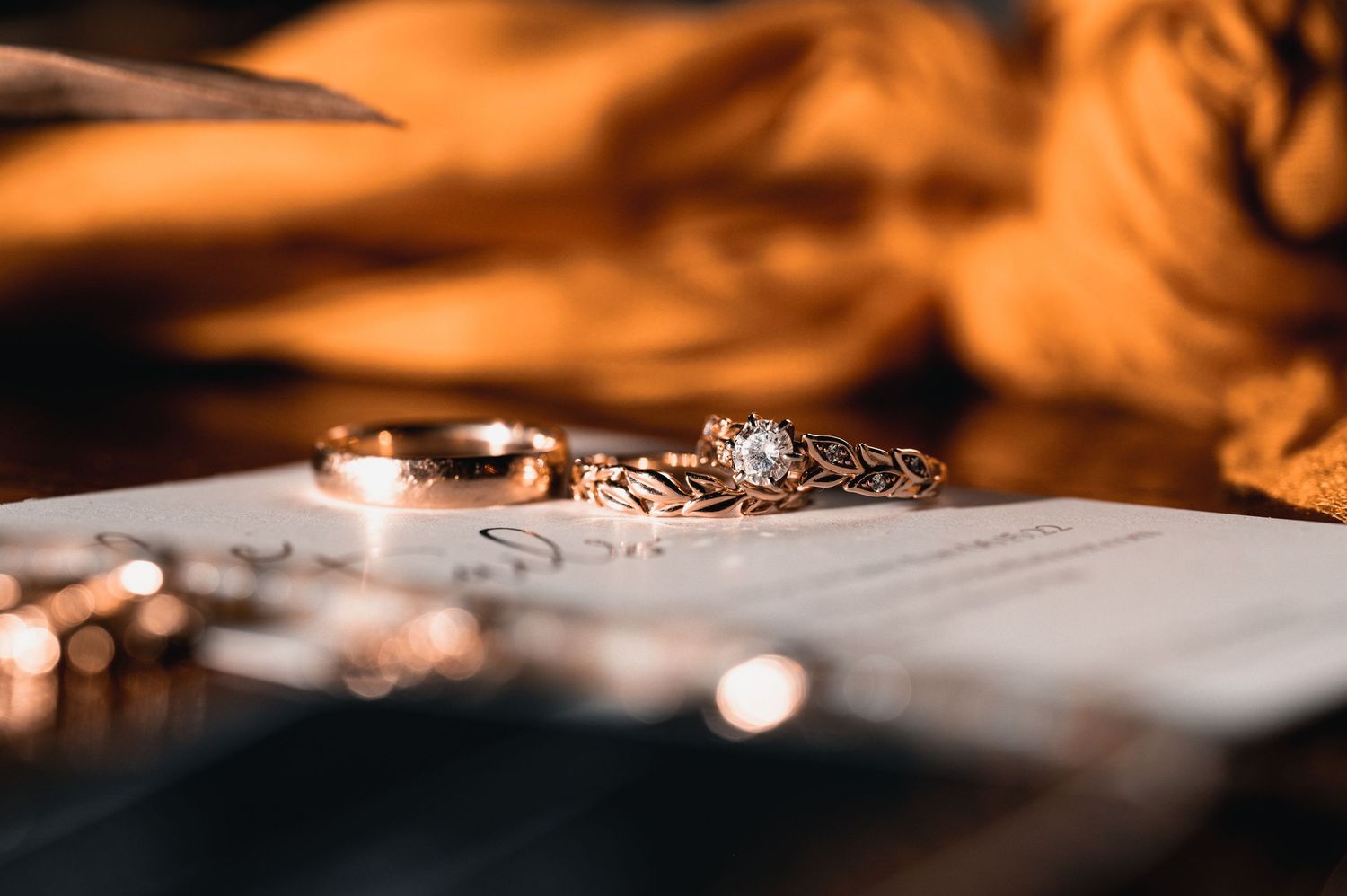 Close-up of wedding details photographed in warm, orange-toned light.