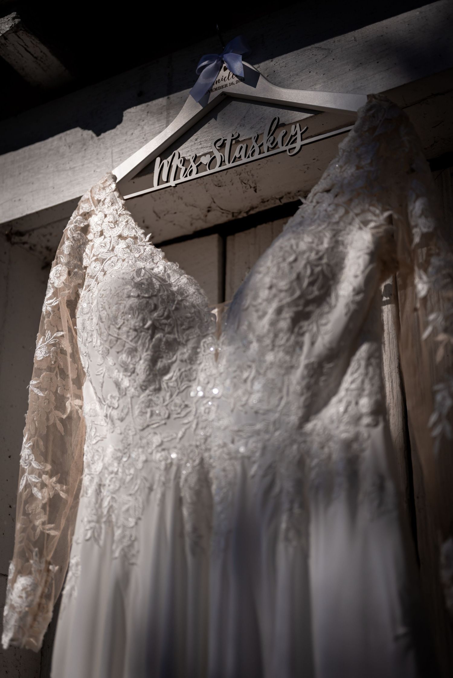 White wedding dress with lace details hanging on display.