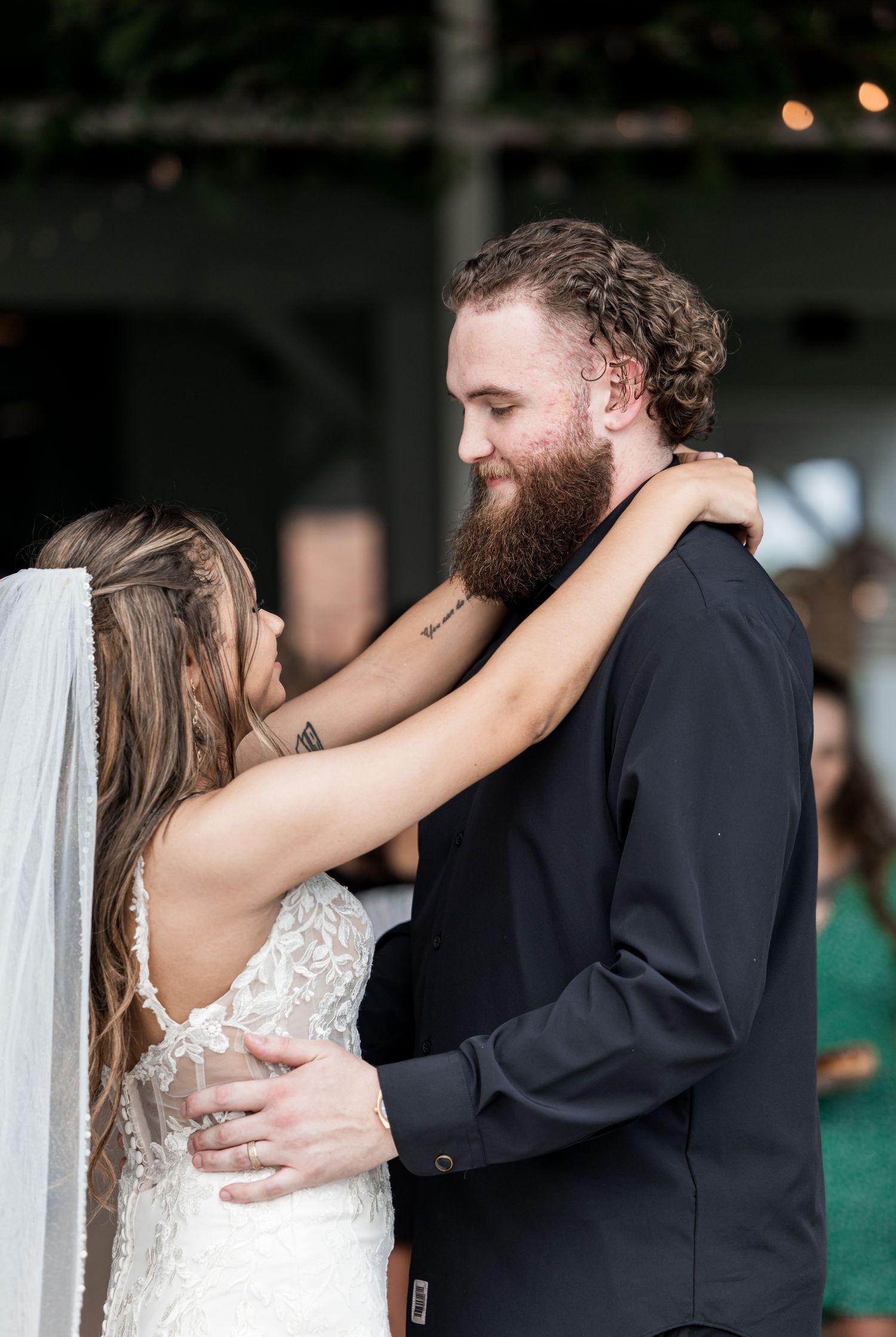 Bride and groom embracing during their first dance at the wedding reception.