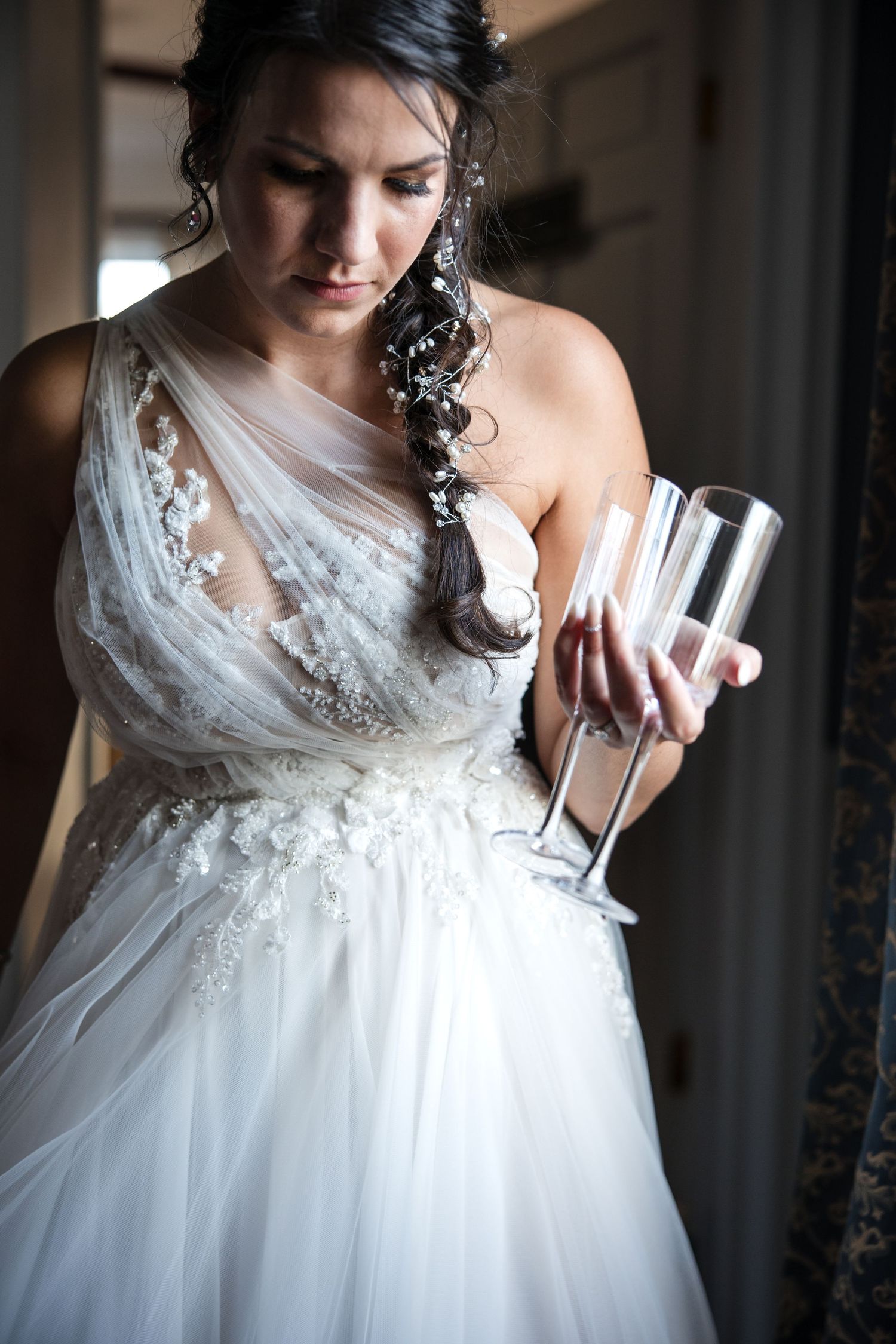 Close-up of a white lace wedding dress bodice with detailed embellishments.