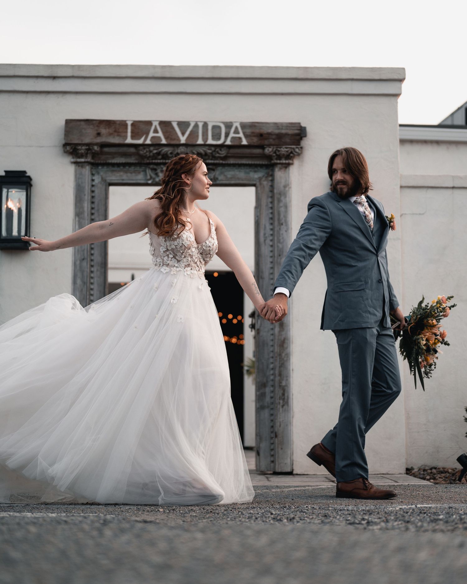 Bride and groom standing together in wedding attire in front of a rustic door in Lynchburg.