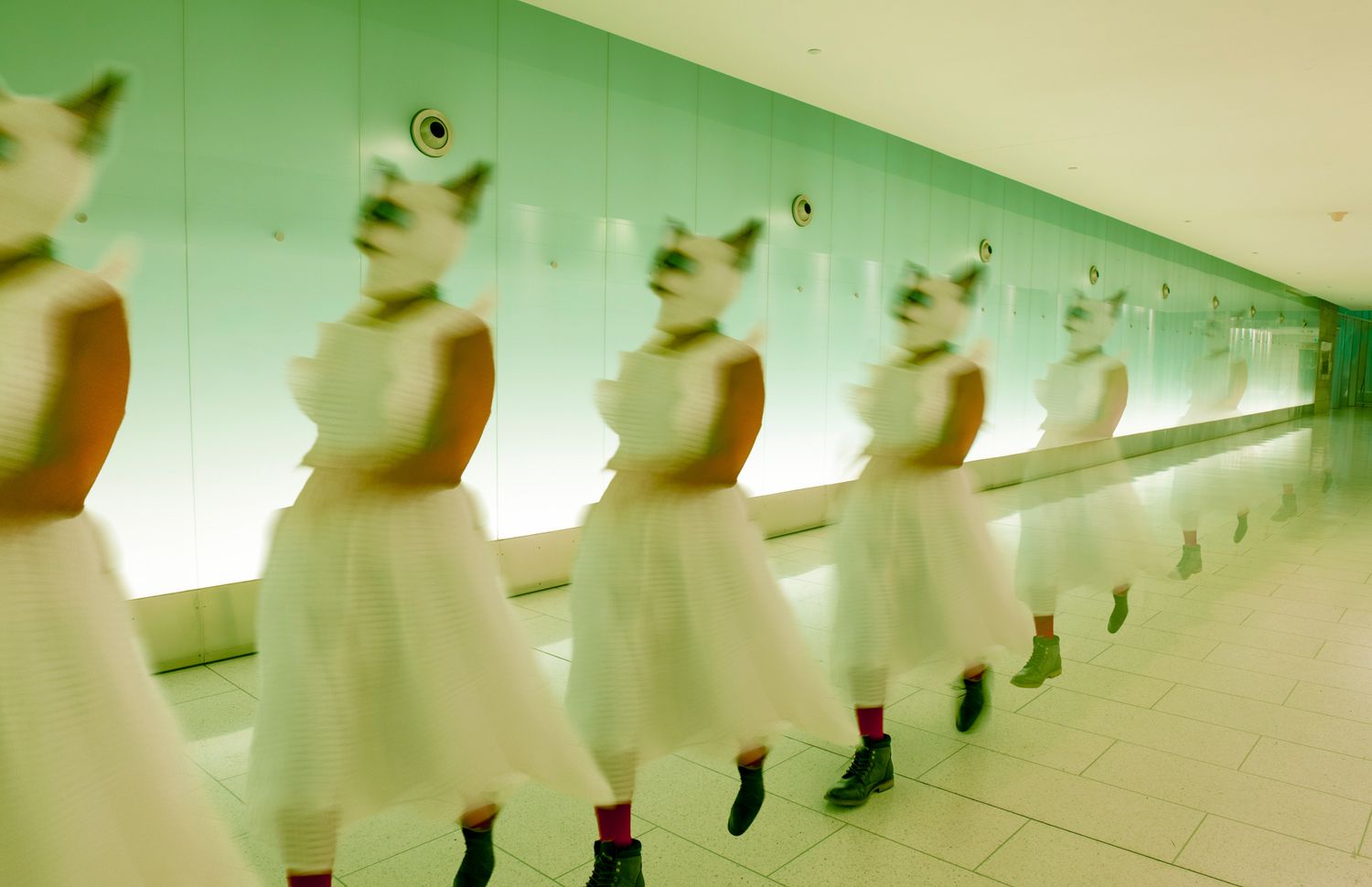Long corridor with repeating fluorescent lights creating symmetrical perspective.