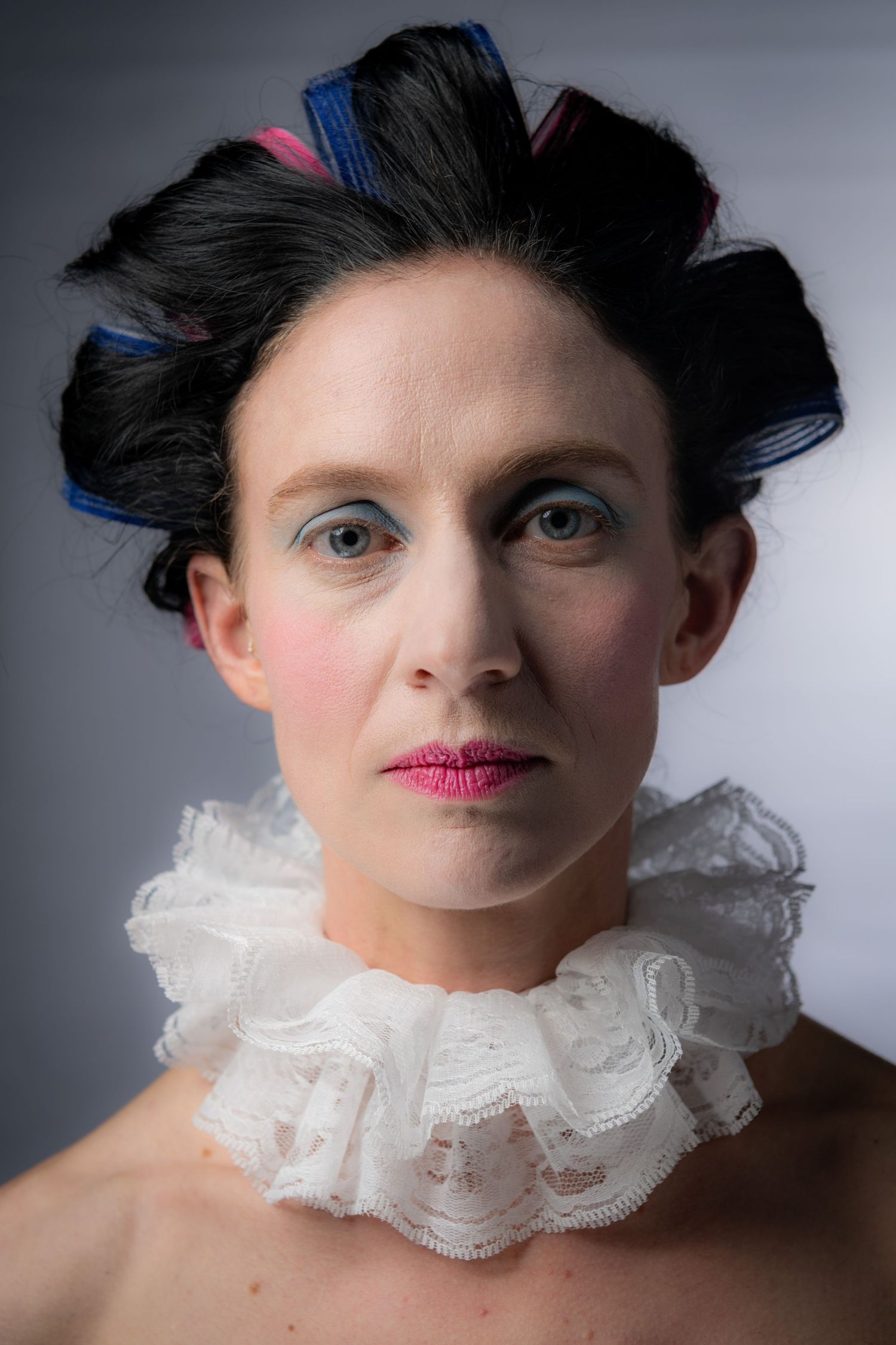 Artistic portrait series featuring a white lace collar and bright pink lipstick against a dark background.