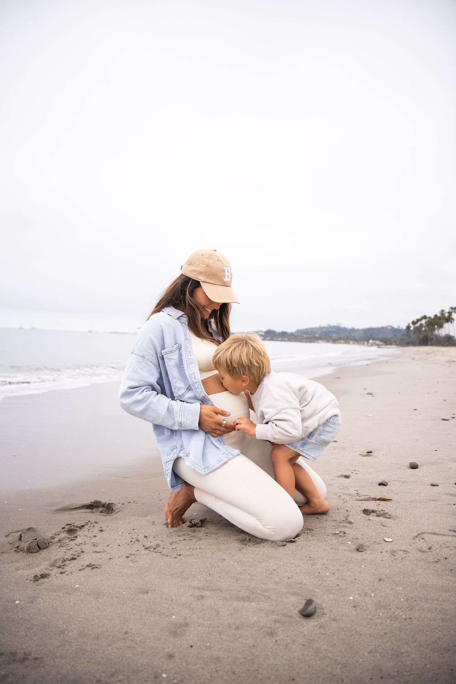 Casual beachside moment captured with two people sitting close together on the sand.