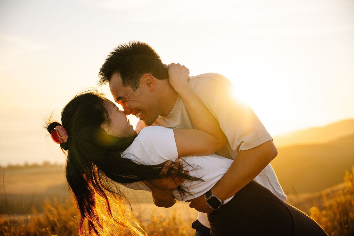 Couple sharing tender moment during golden hour photoshoot.