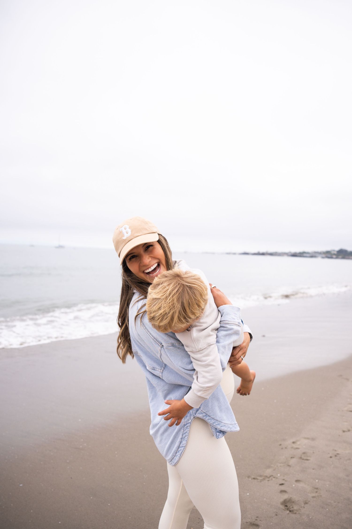 People in light clothing sharing joyful moments along the shoreline.