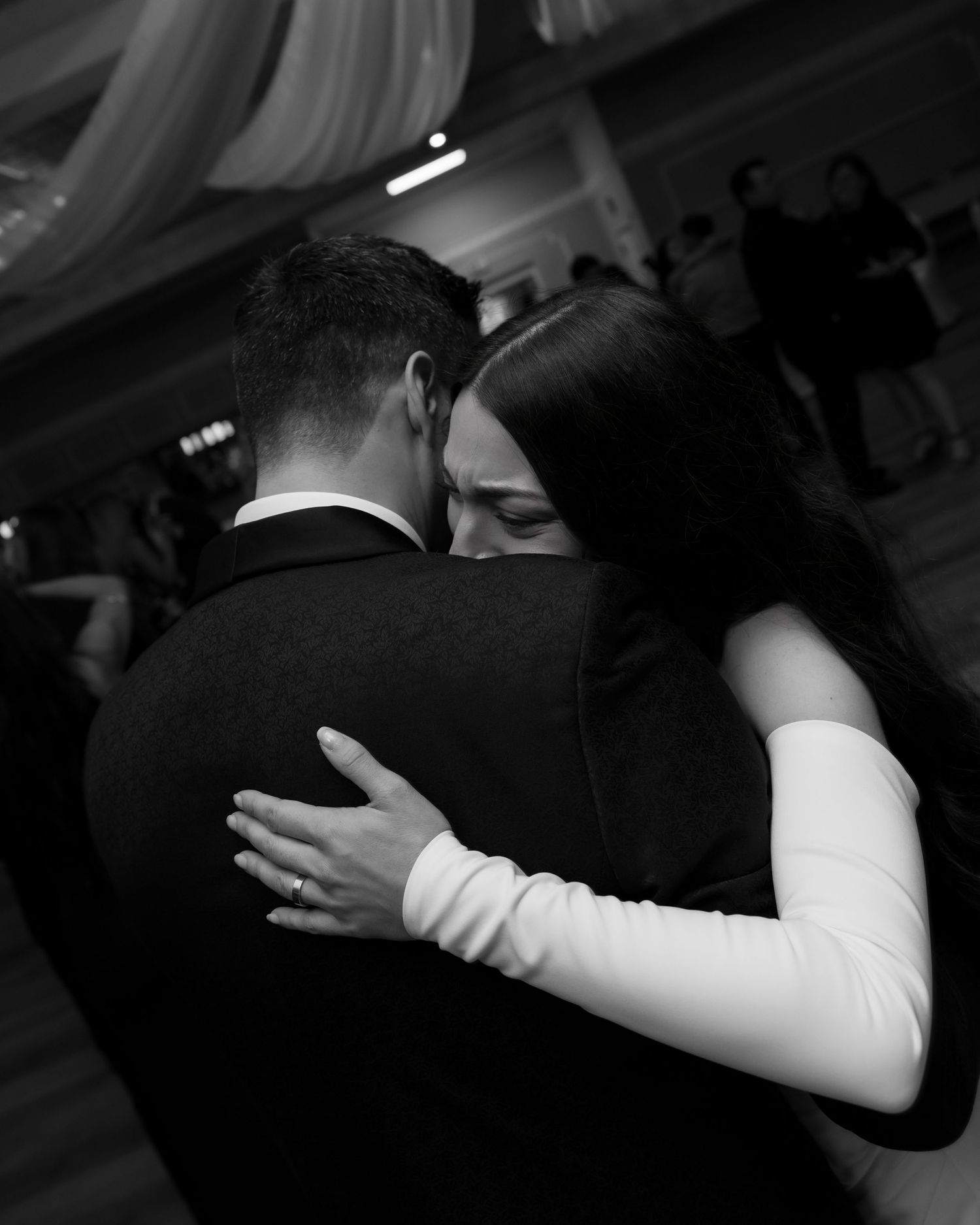 Black and white photo of couples slow dancing at wedding reception.