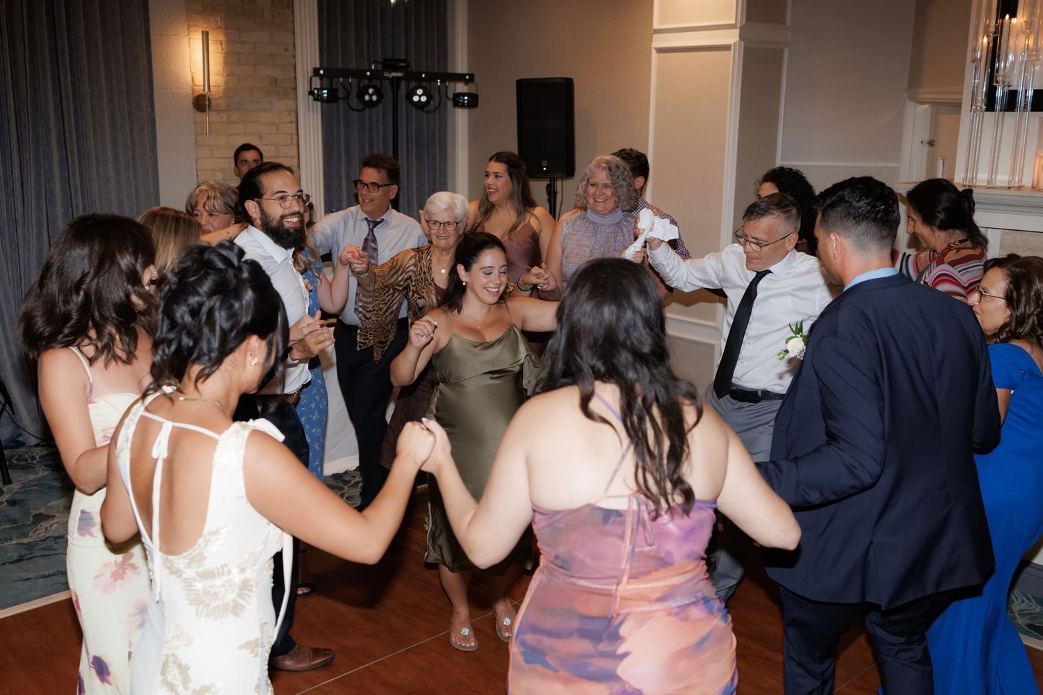 Wedding celebration with guests dancing together in a reception hall.