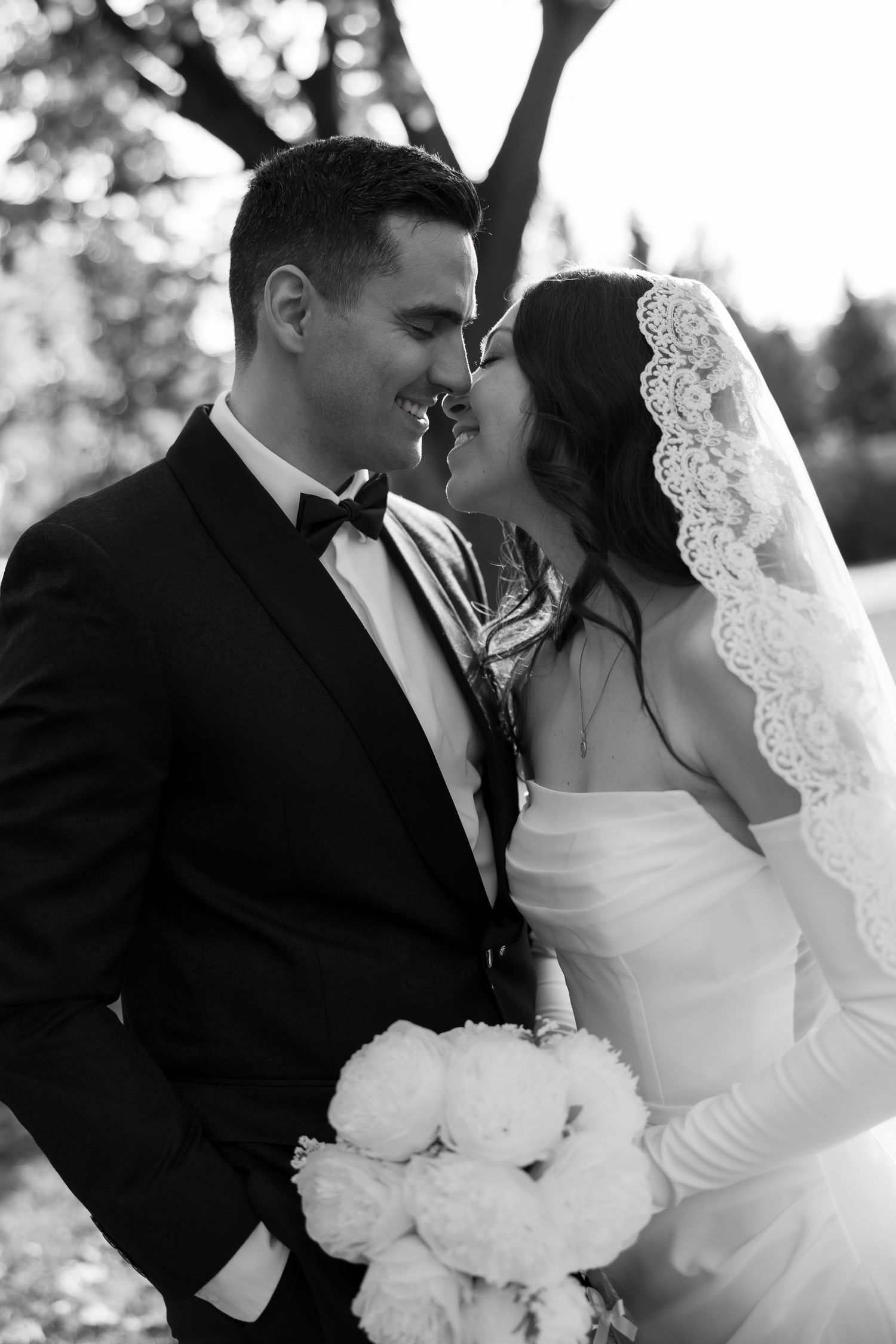 Romantic black and white wedding portrait showing intimate moment between newlyweds.
