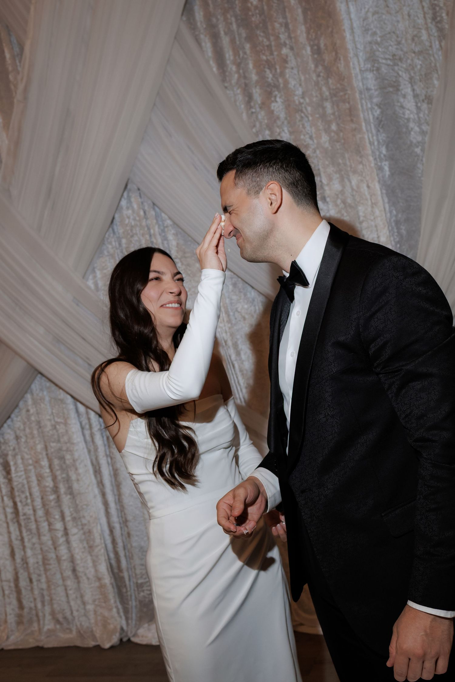 Couple sharing romantic dance moves against sparkly backdrop at wedding reception.