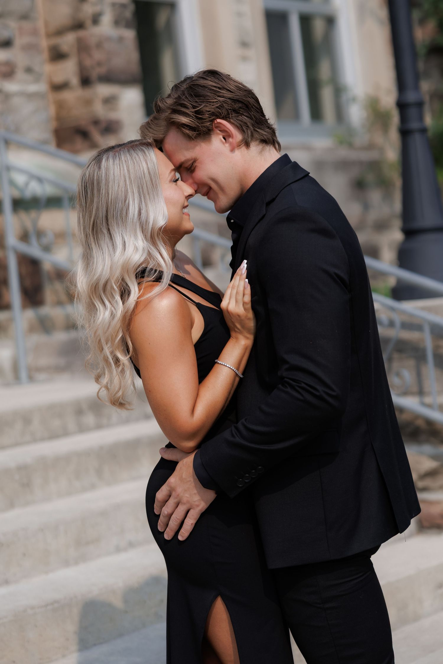 Intimate portrait series of couple embracing near stone steps.