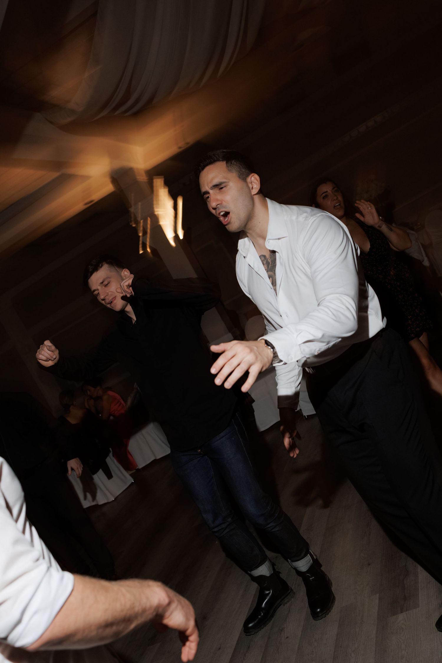 Dynamic dance moves captured in sequence at a dimly lit wedding reception venue.