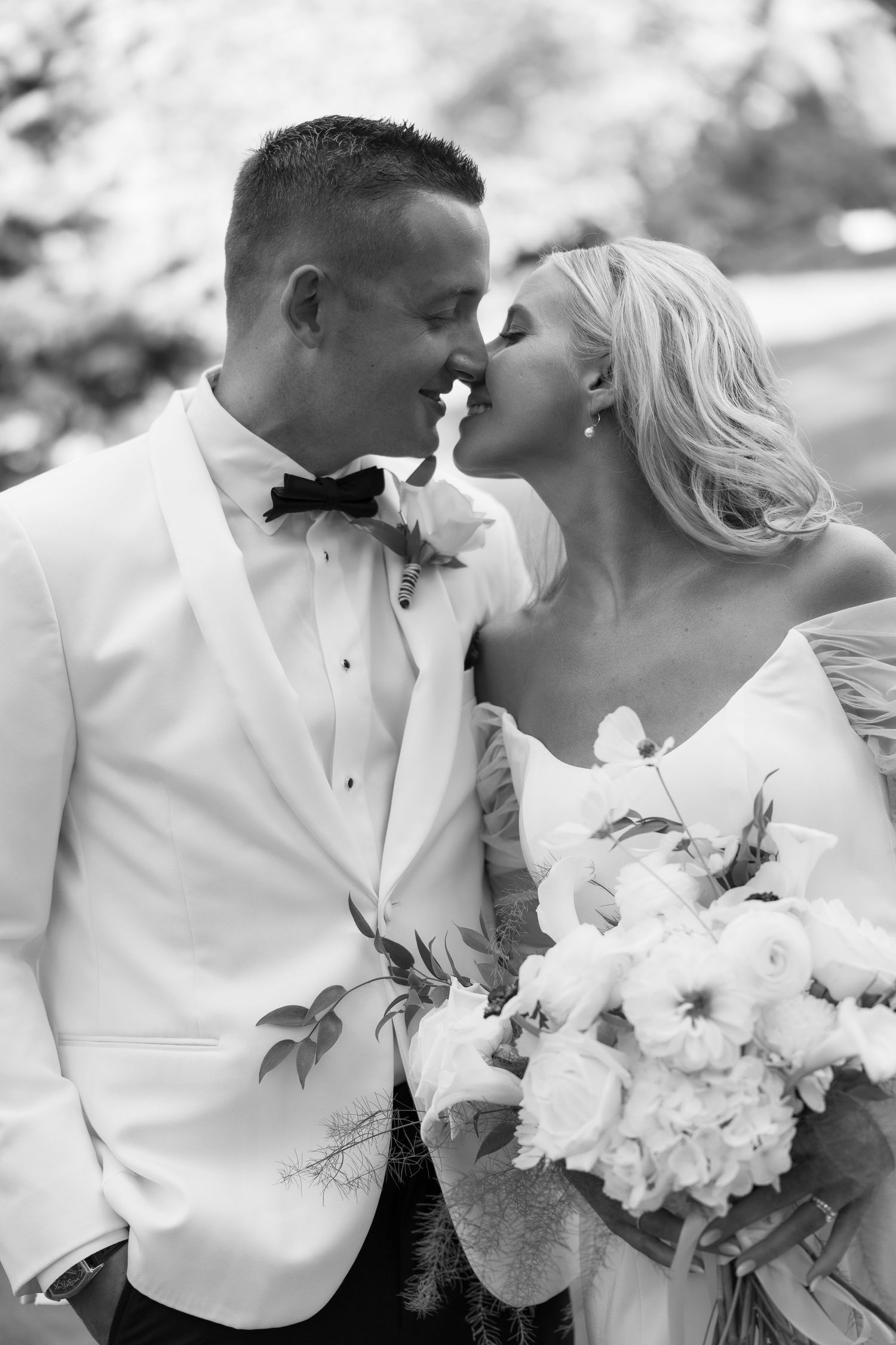 Romantic black and white portraits of newlyweds with white floral bouquet.