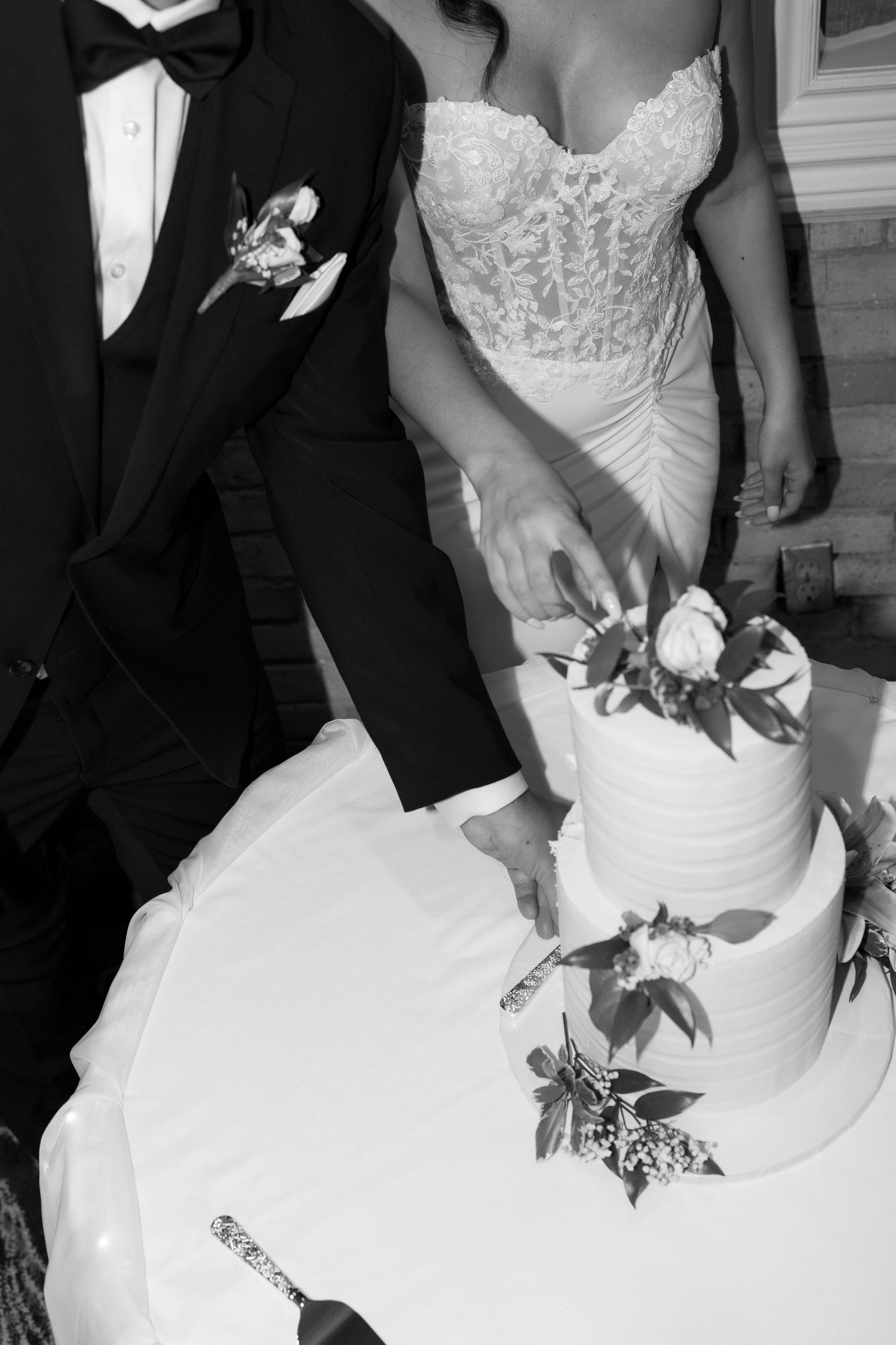 Close-up details of a white wedding dress and formal attire during a celebration.