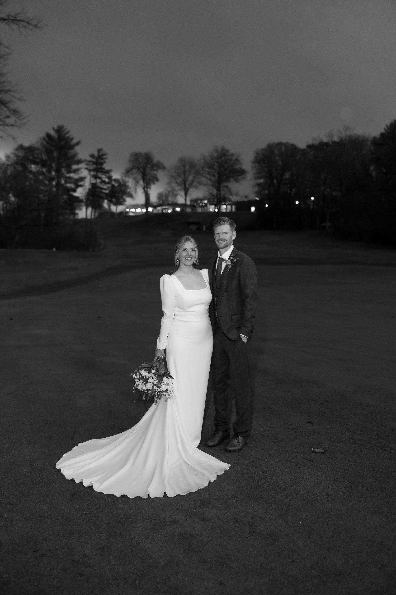 Black and white wedding photos show couple posing together on a scenic outdoor lawn at dusk.