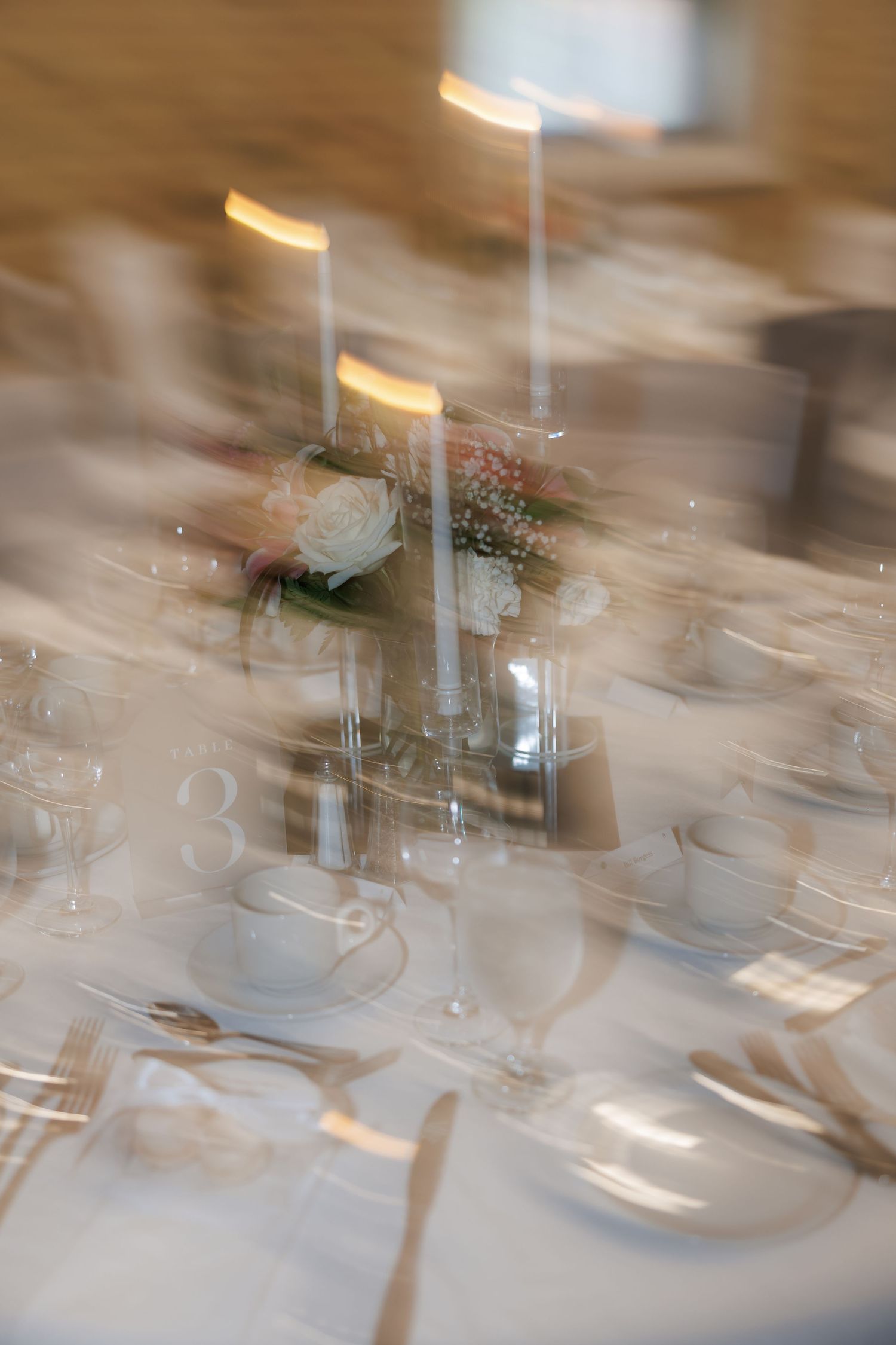 Elegant table settings with glassware and place settings at a formal event create a dreamy, blurred atmosphere.