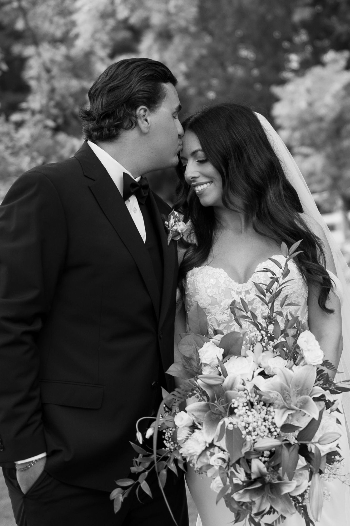 A romantic black and white wedding photo series featuring a beautiful bouquet of lilies and intimate moments.