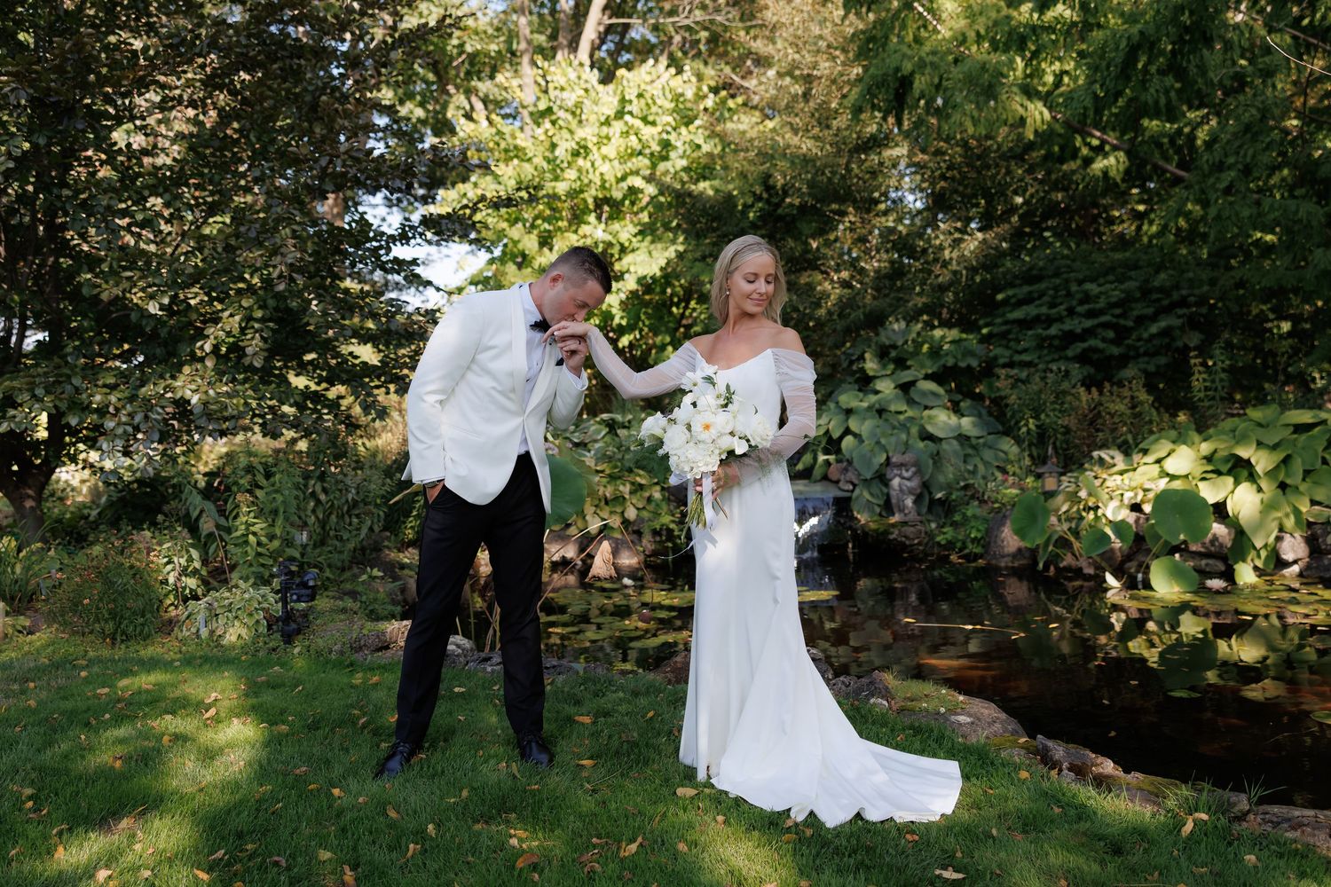 Wedding party enjoying playful moments together in a sunlit wooded garden setting.