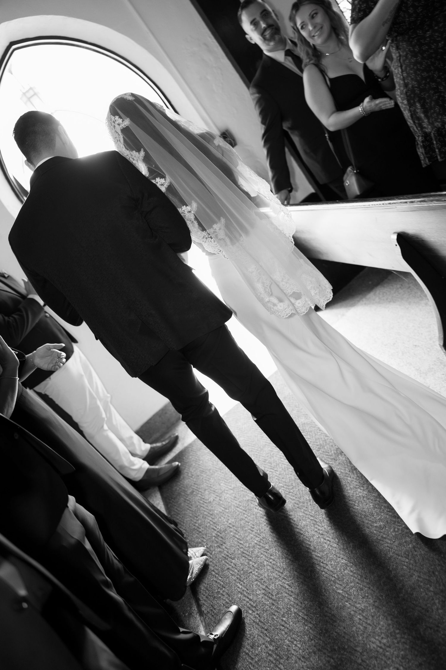 Black and white silhouettes of a wedding couple dancing together on a dark floor.